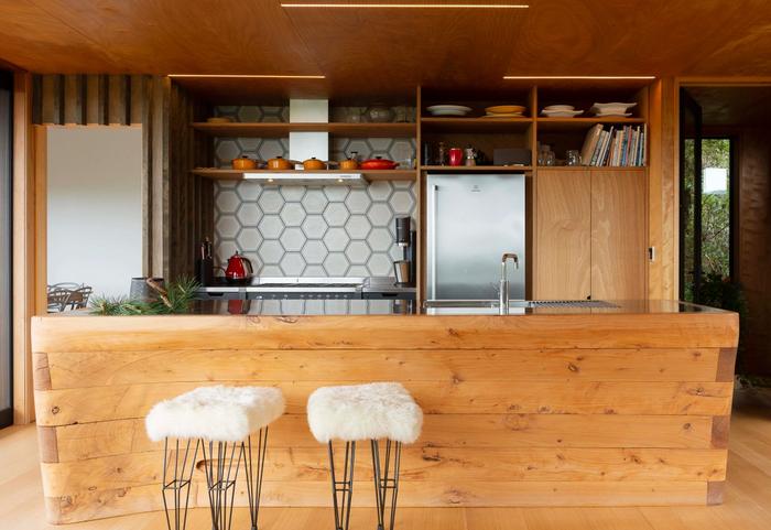 a wooden kitchen island that features a curved edge