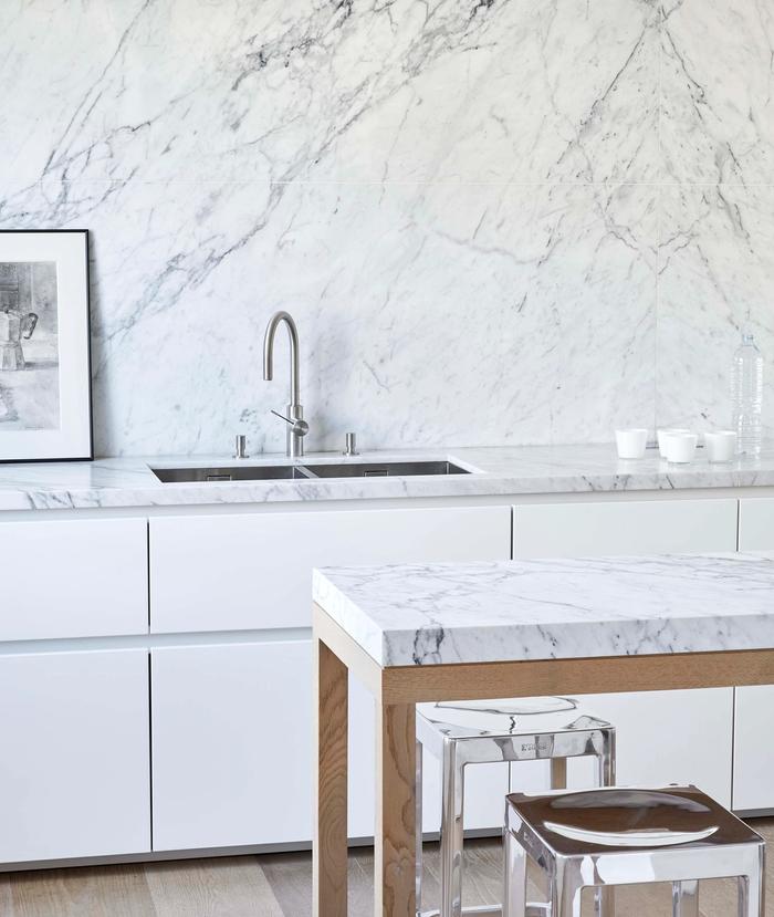 deeply veined marble used as a splashback and benchtop in a white kitchen