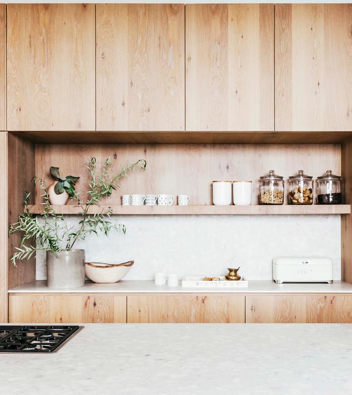 A timber kitchen with open shelving above the bench