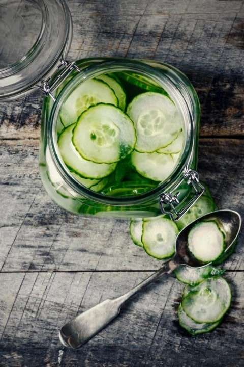 Jar of pickled cucumbers on wooden background