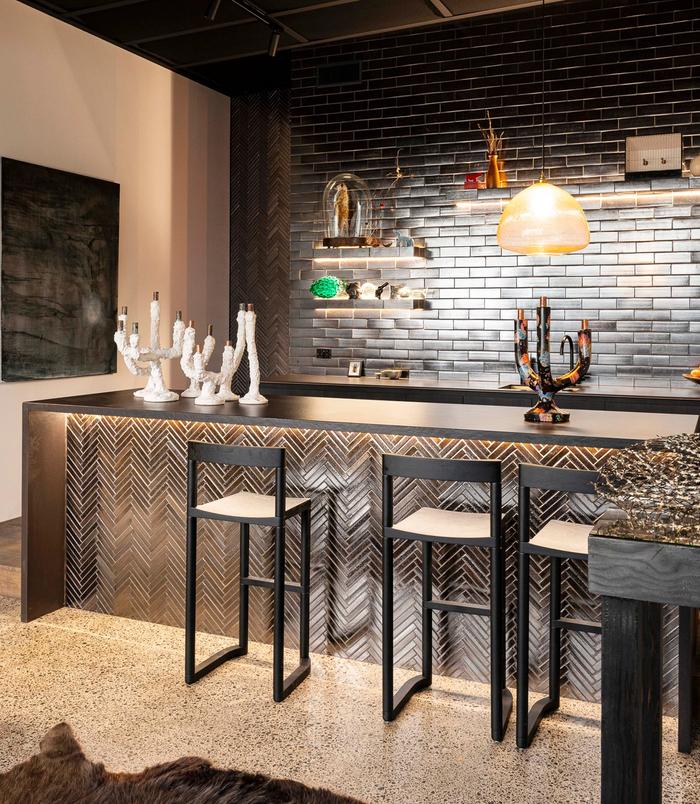 a black kitchen with glossy black subway tiles