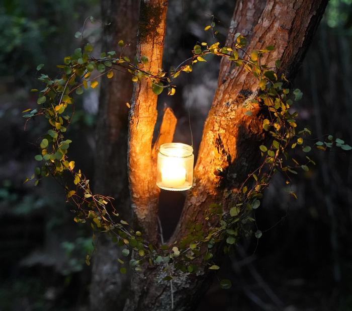 a candle in a jar with a heart shaped frame