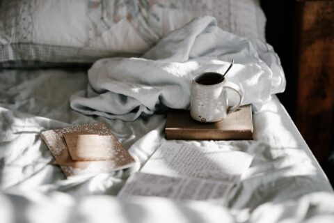 A mug and books on a bed