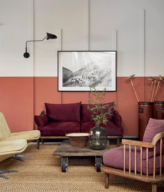 Half pink and white wall with maroon couch