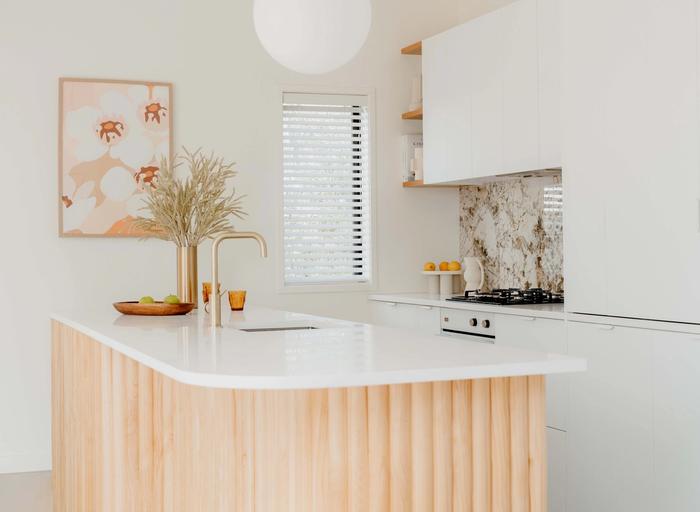 Kitchen island with curved coral tiles around the font