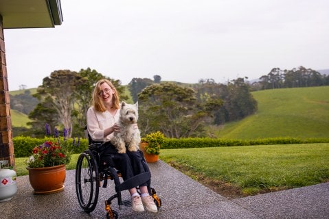 Grace Stratton outside on wheelchair with dog