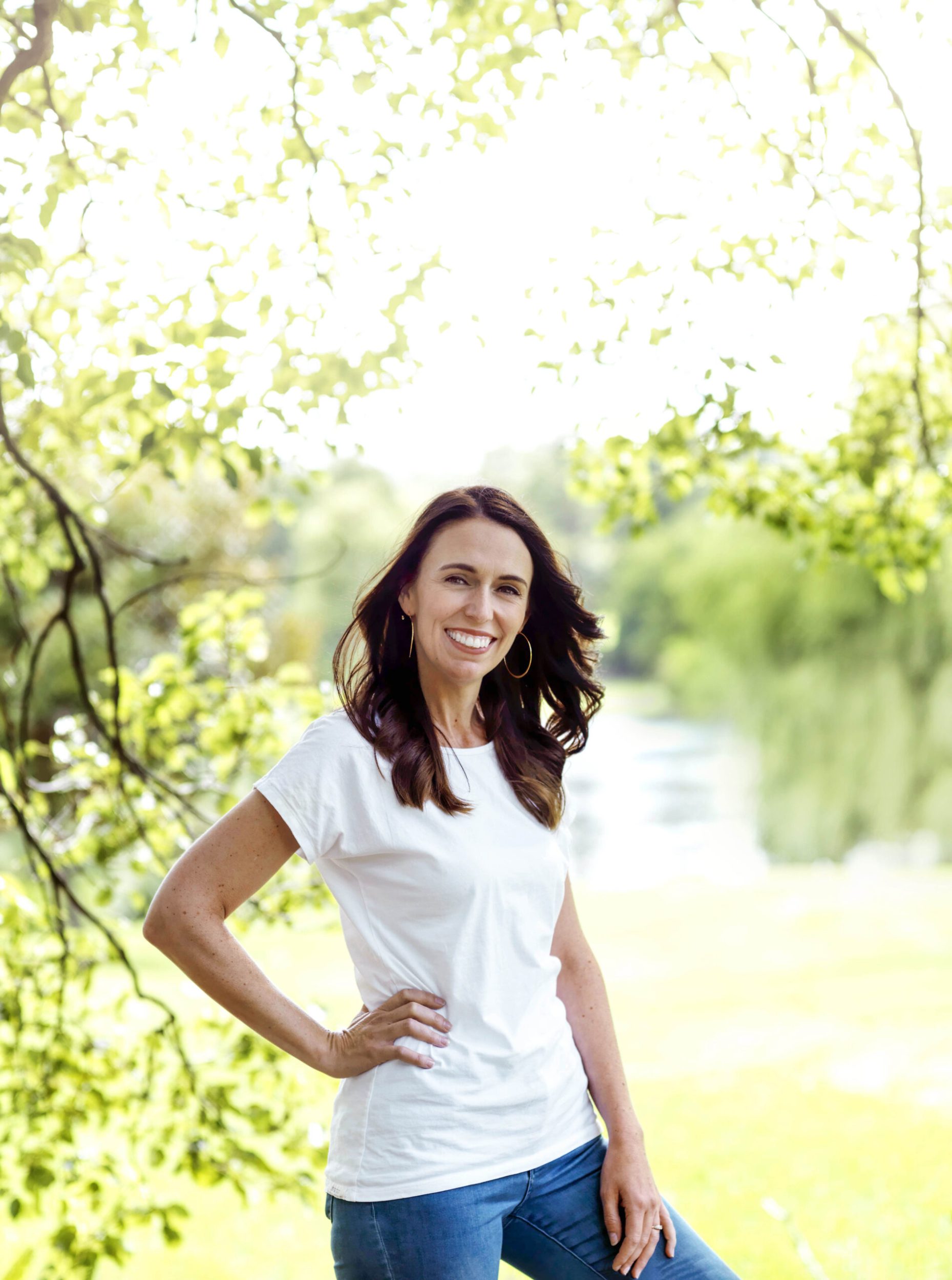 Jacinda Ardern wearing white shirt and blue jeans with hand on hip