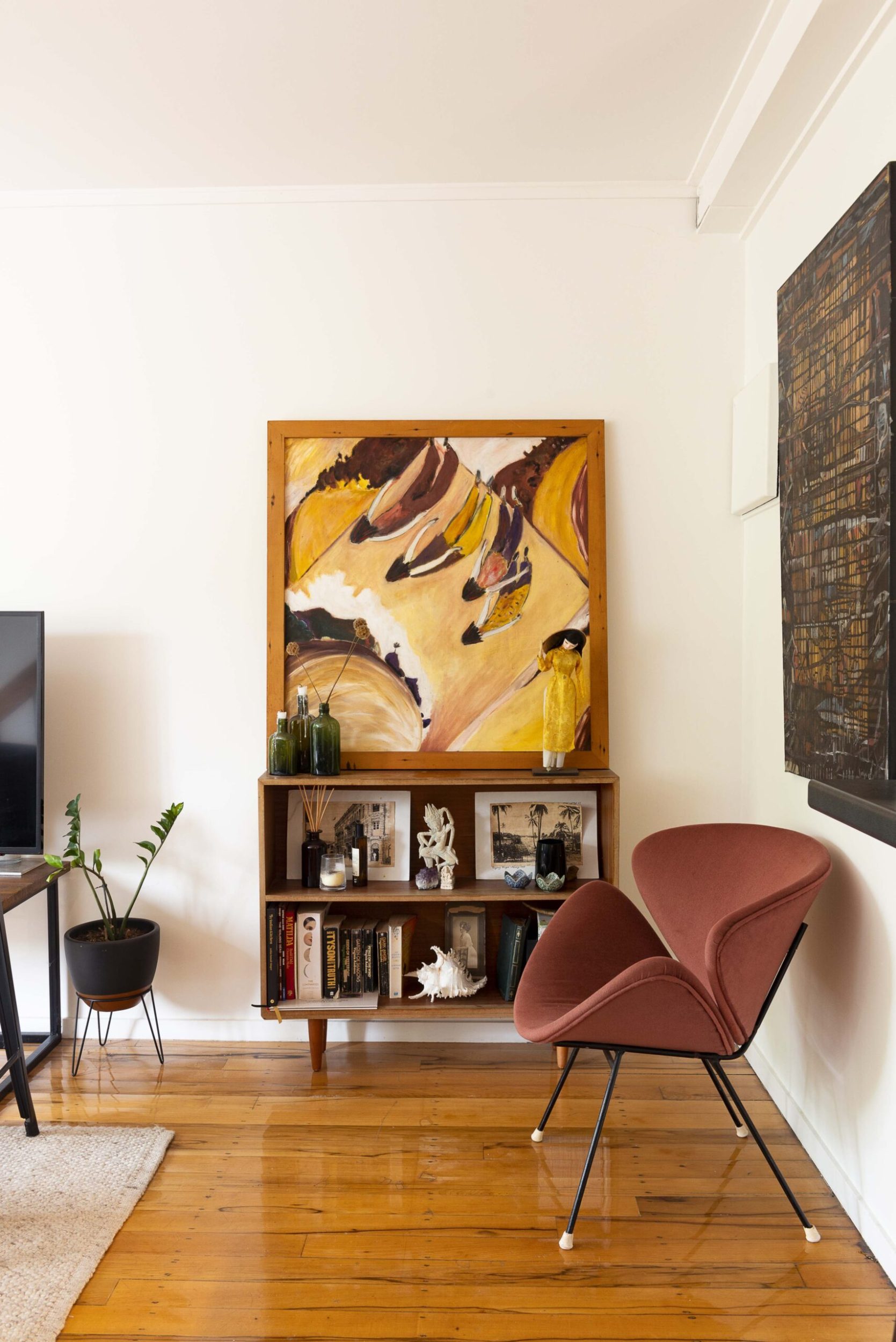 A white room with polished wooden floors, a brown cabinet and large artwork by Linga Art