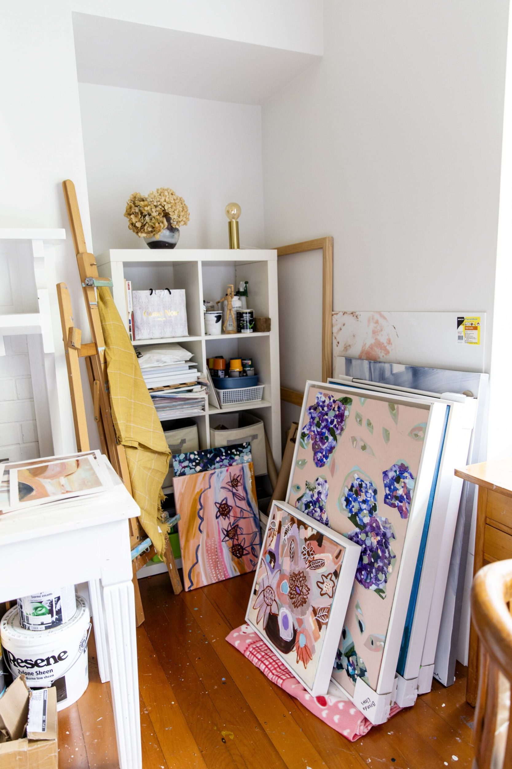 An assortment of artworks by Brenda Clews leaning against wall in art studio