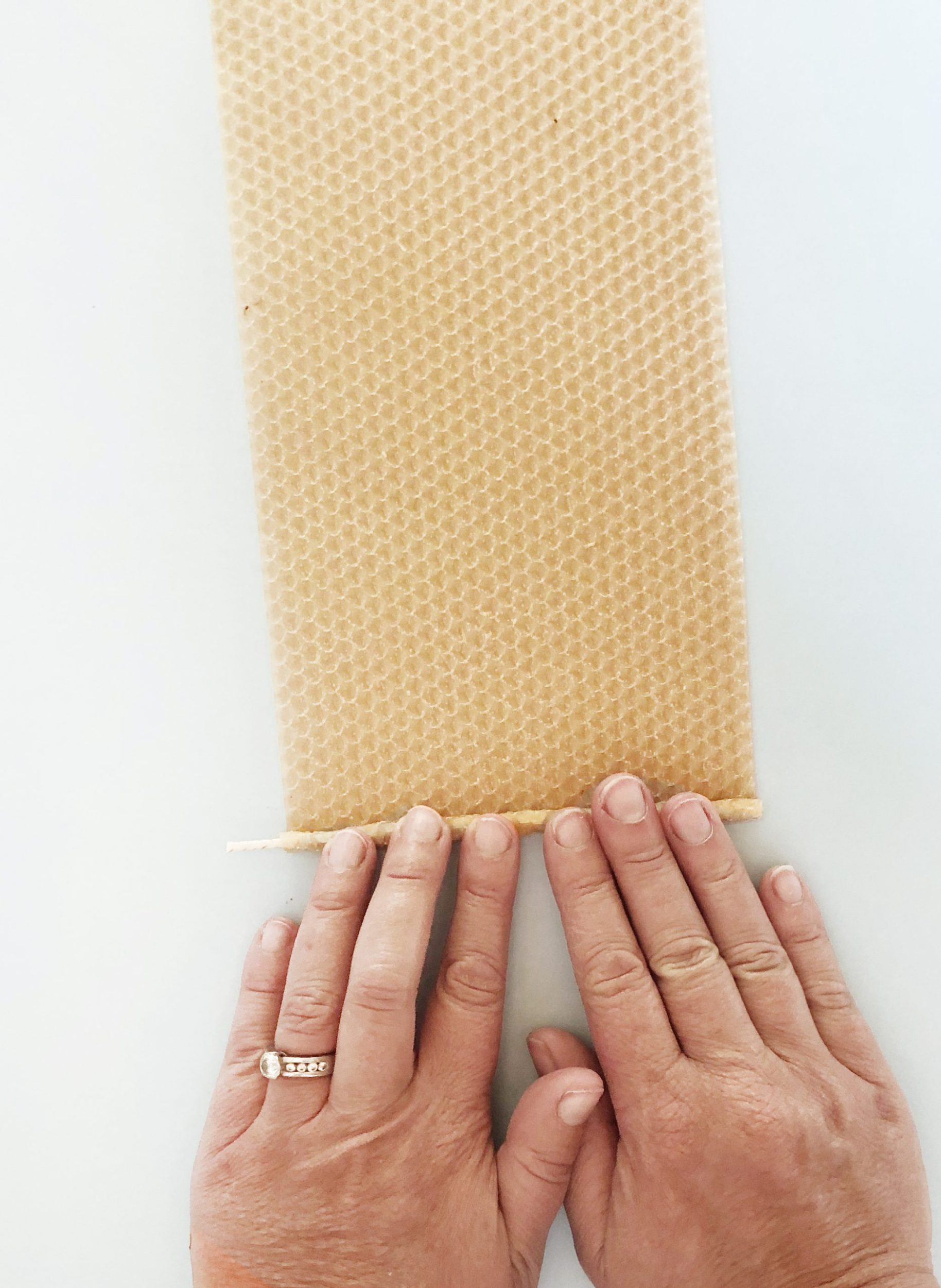 Two hands rolling beeswax