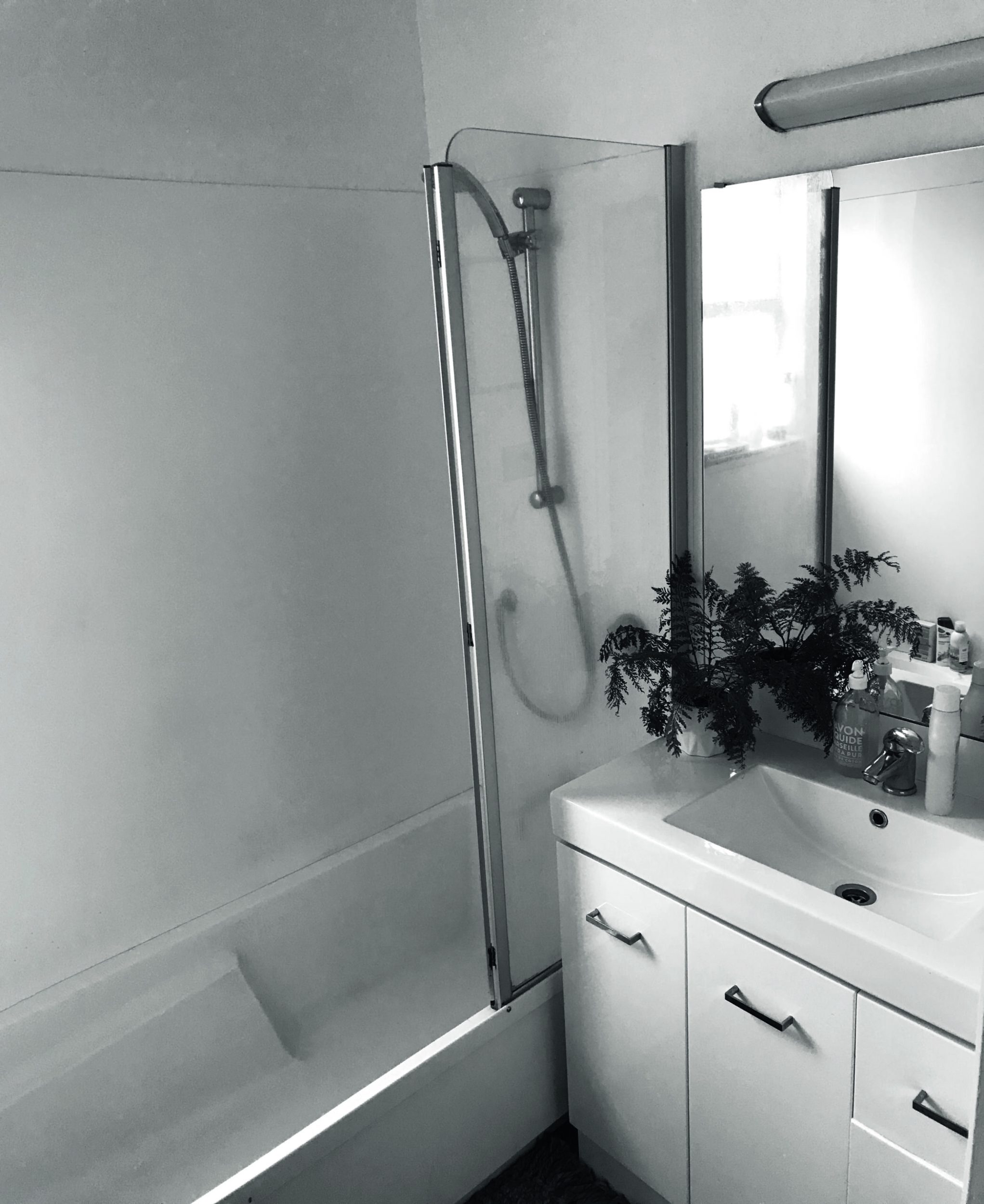 Black and white photograph of a small bathroom