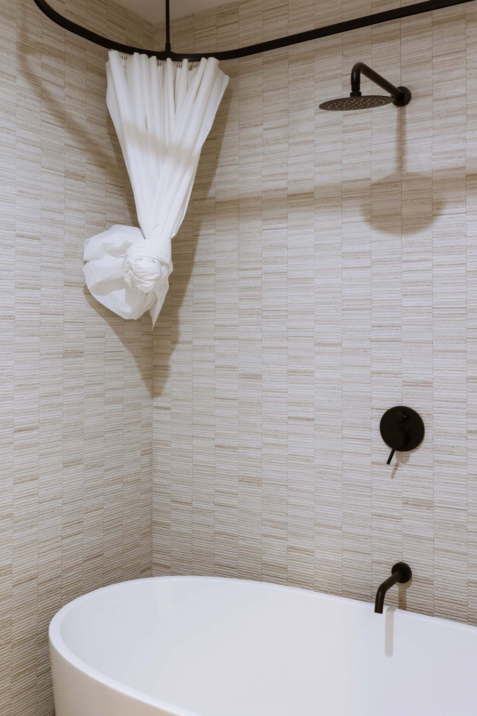 A round white bathroom against beige tiles 