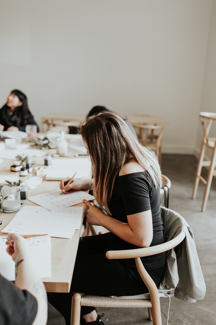 A woman at a career progression workshop writing notes.