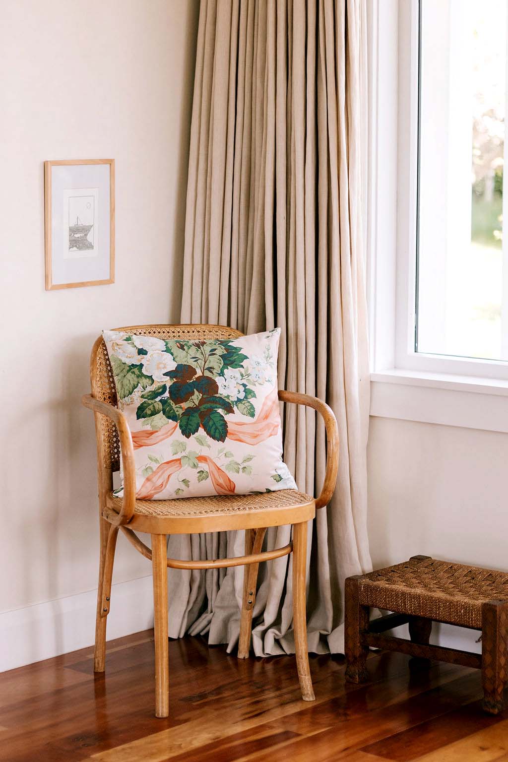 A wooden chair with a colourful The Brim cushion in the corner of a room