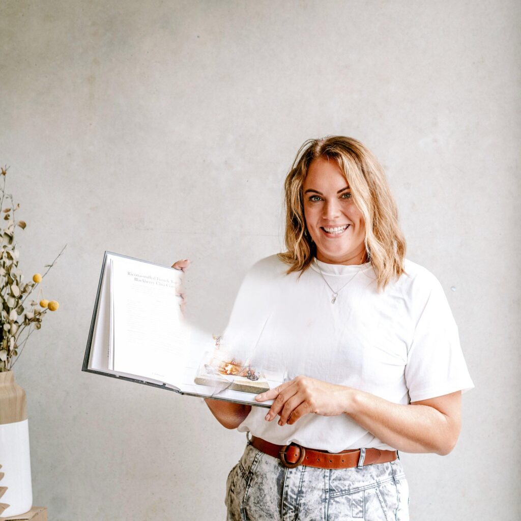 Cherie Metcalfe wearing a white top and holding book