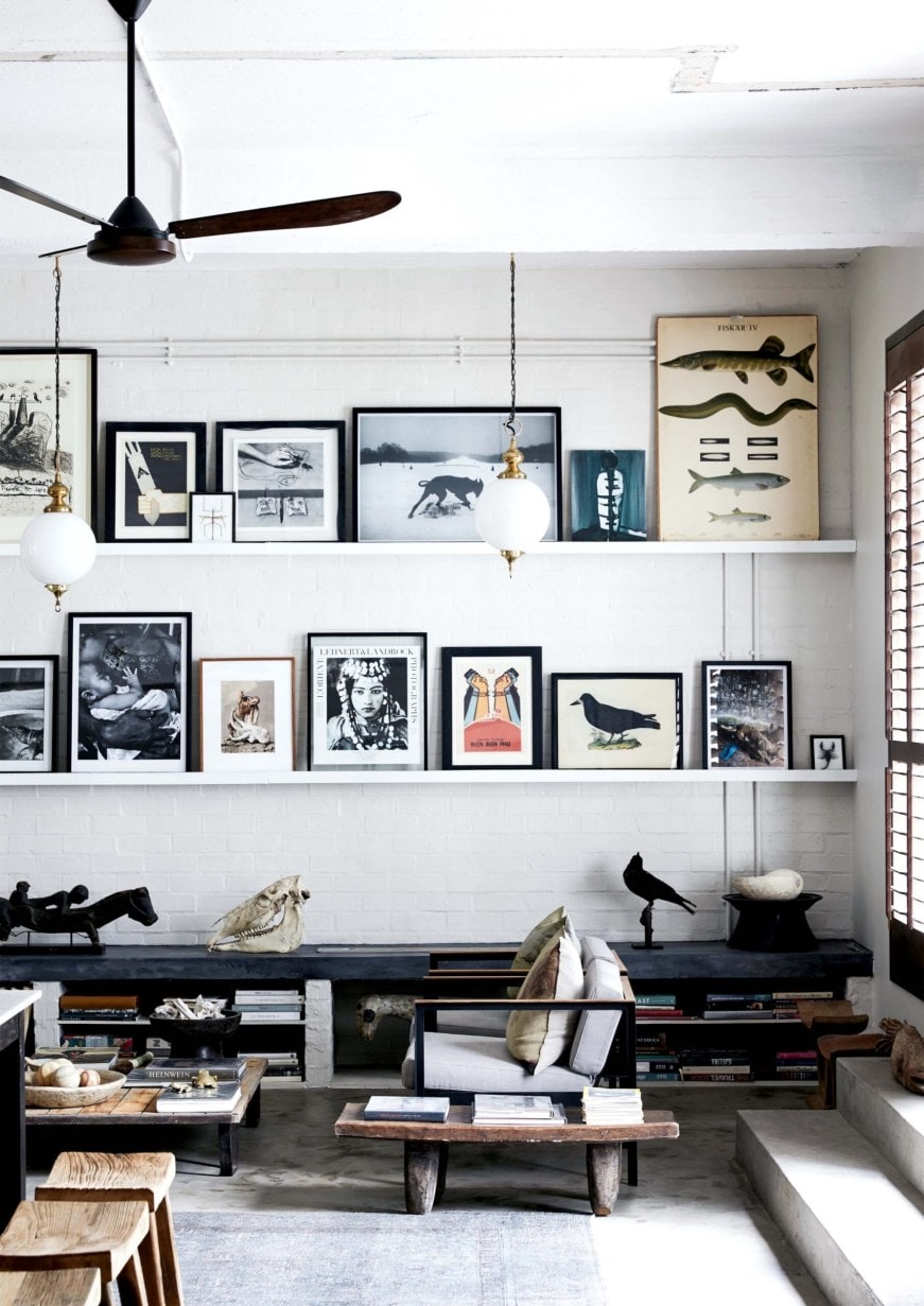 Living room with low black cabinets and shelves with assorted art 