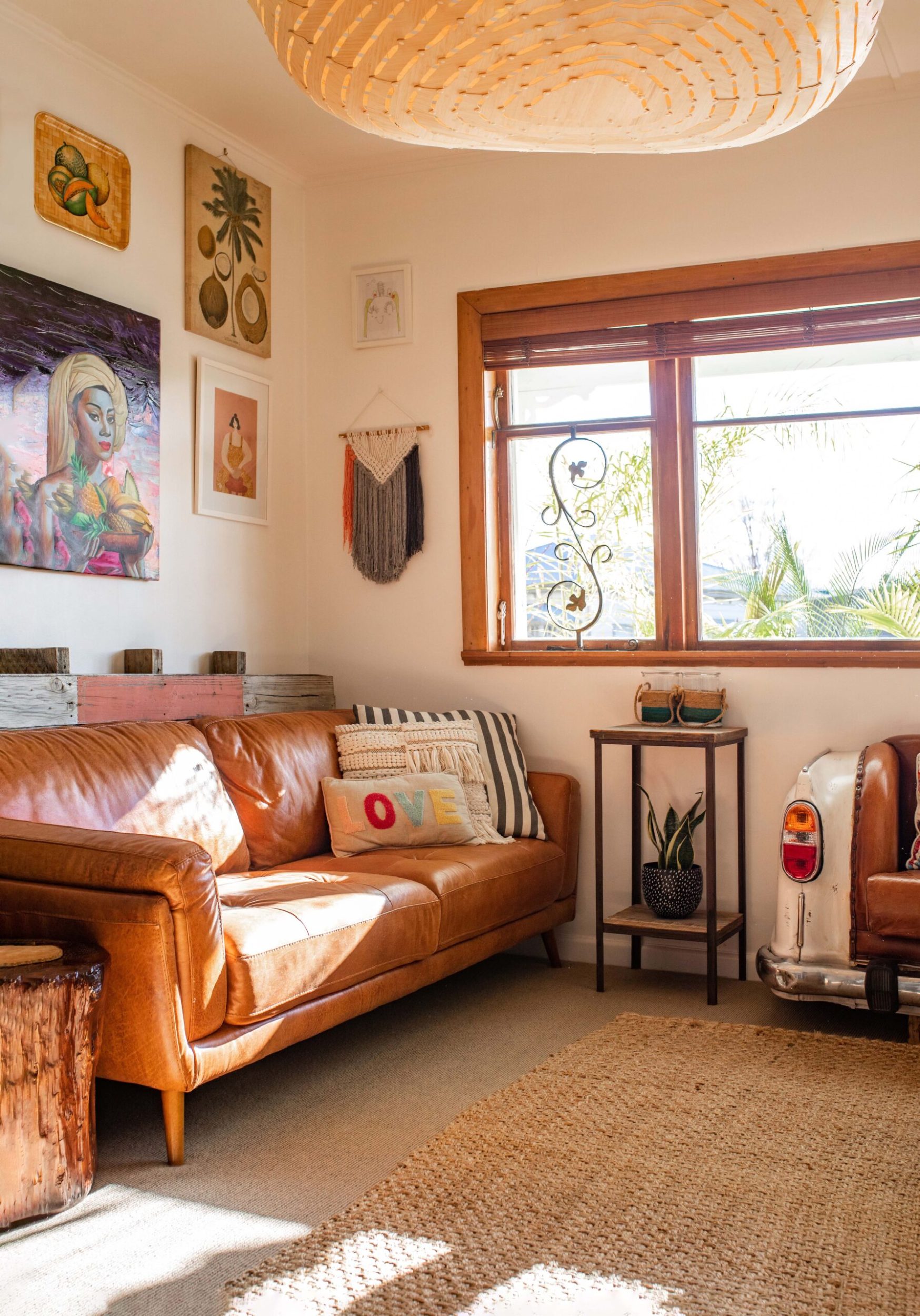 A living room bathed in light with a tan couch and artwork on the wall