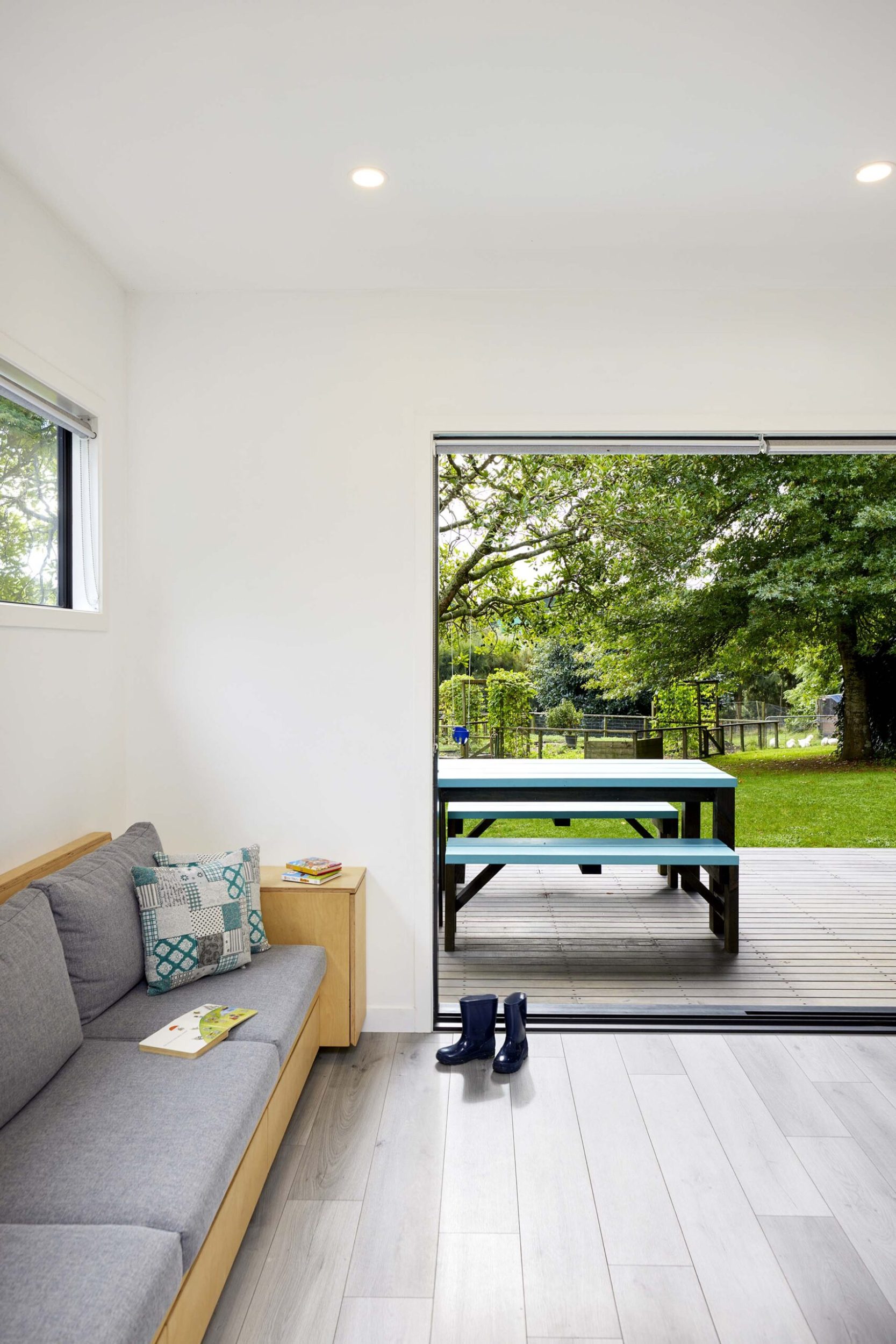 A living room space with a large open door facing a deck