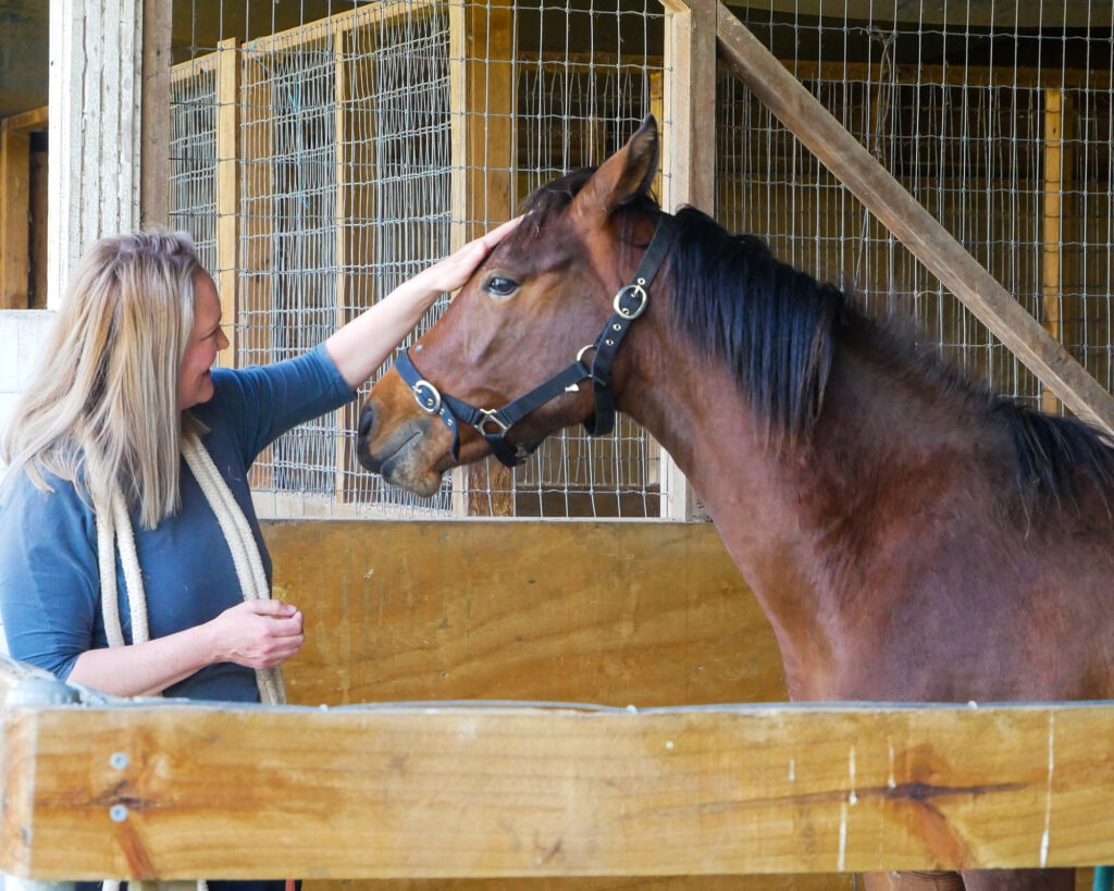 Katrina McClelland with horse in stable