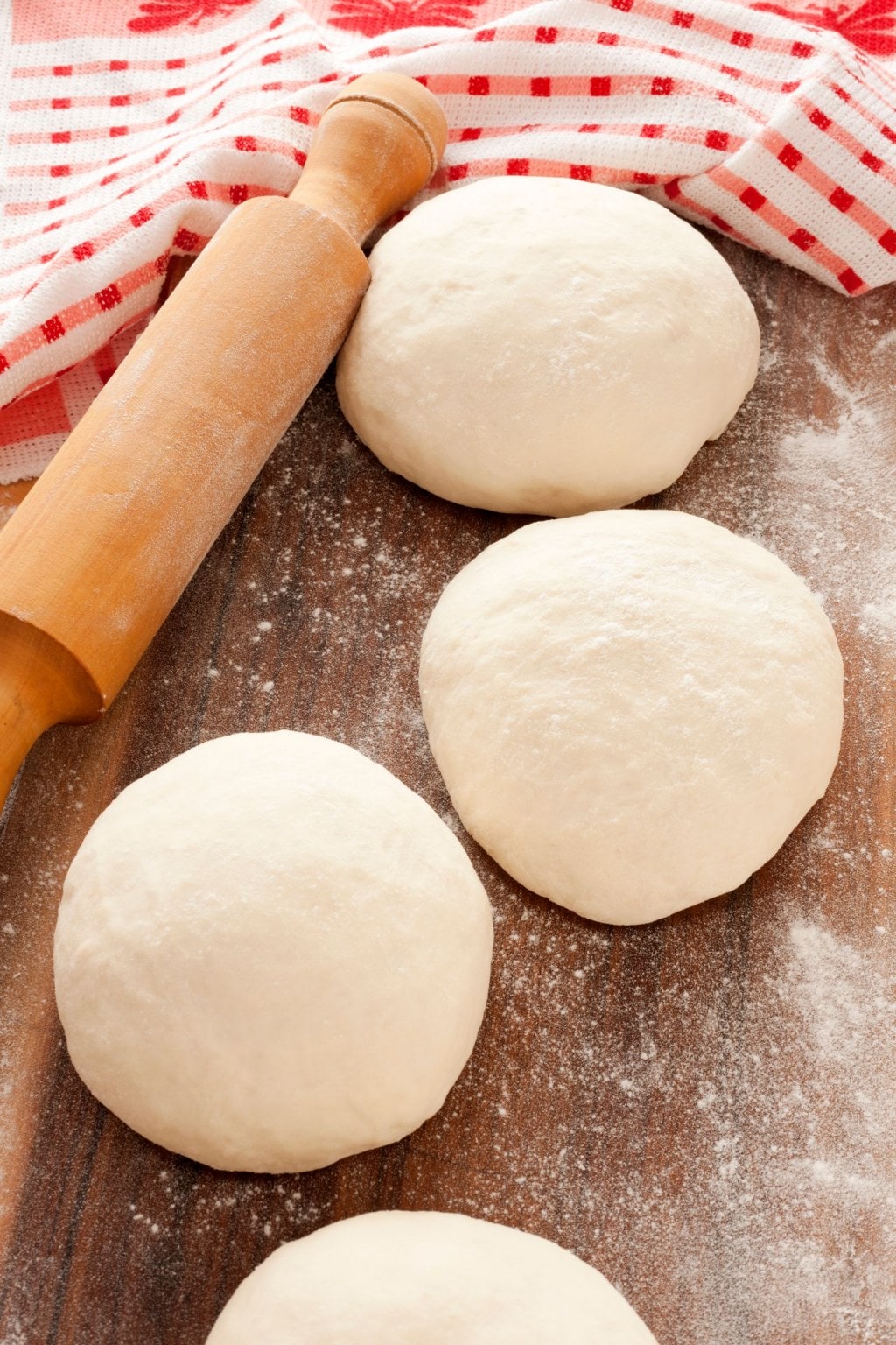Dough balls ready to be rolled over table for making pizza
