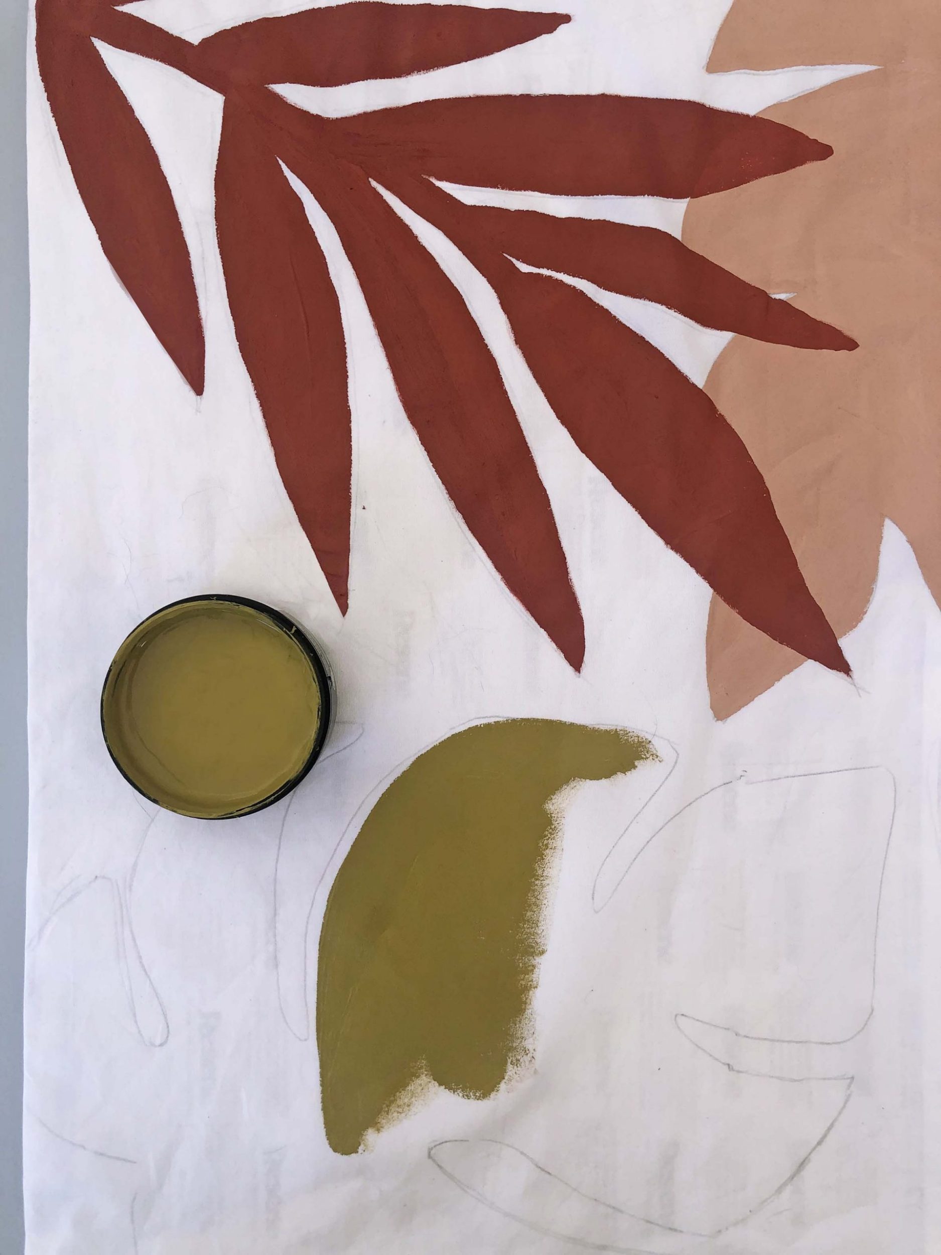 Leaf outlines being painted on white pillows