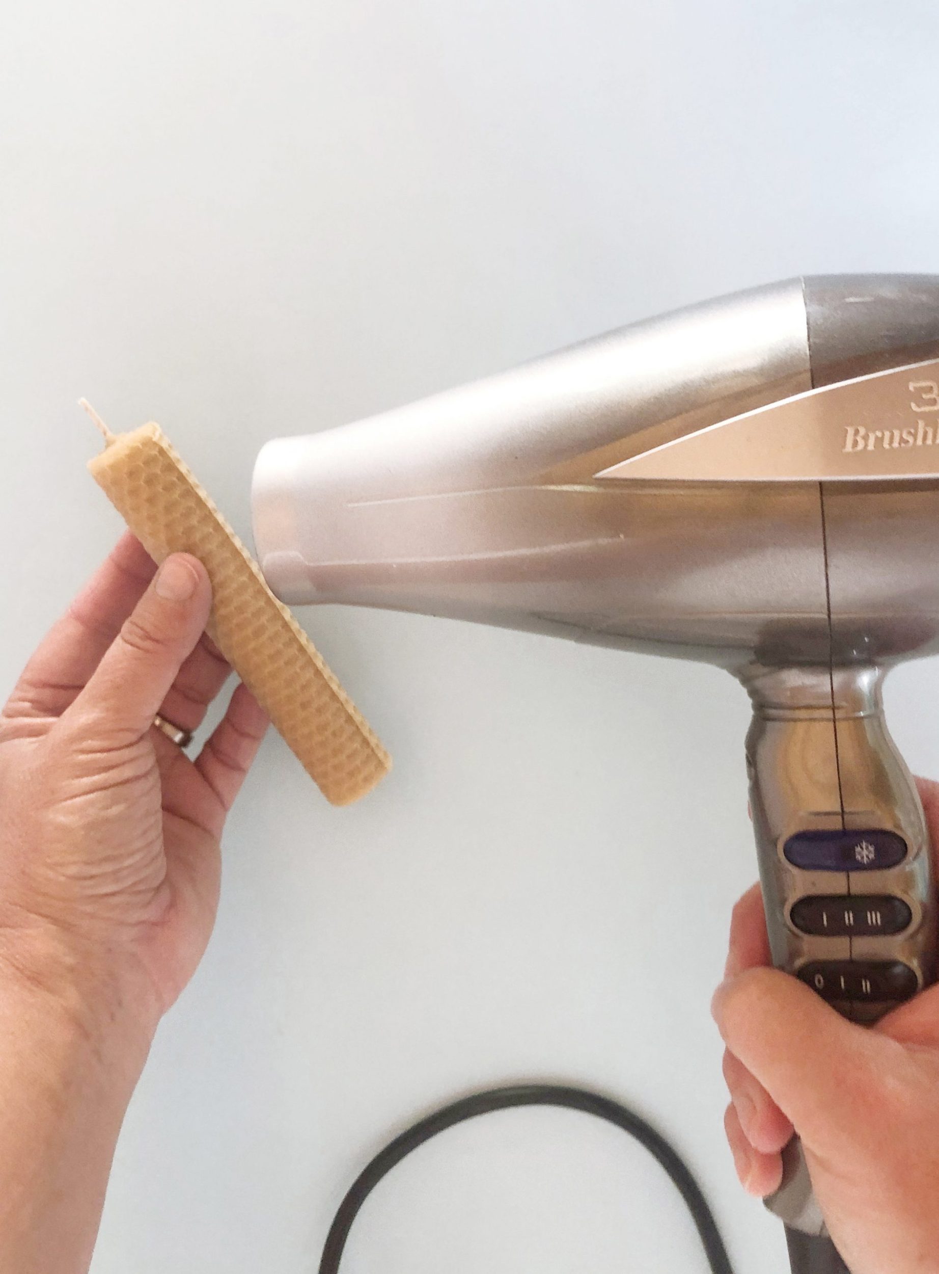 Hairdryer to warming the wax edge of bees wax candle