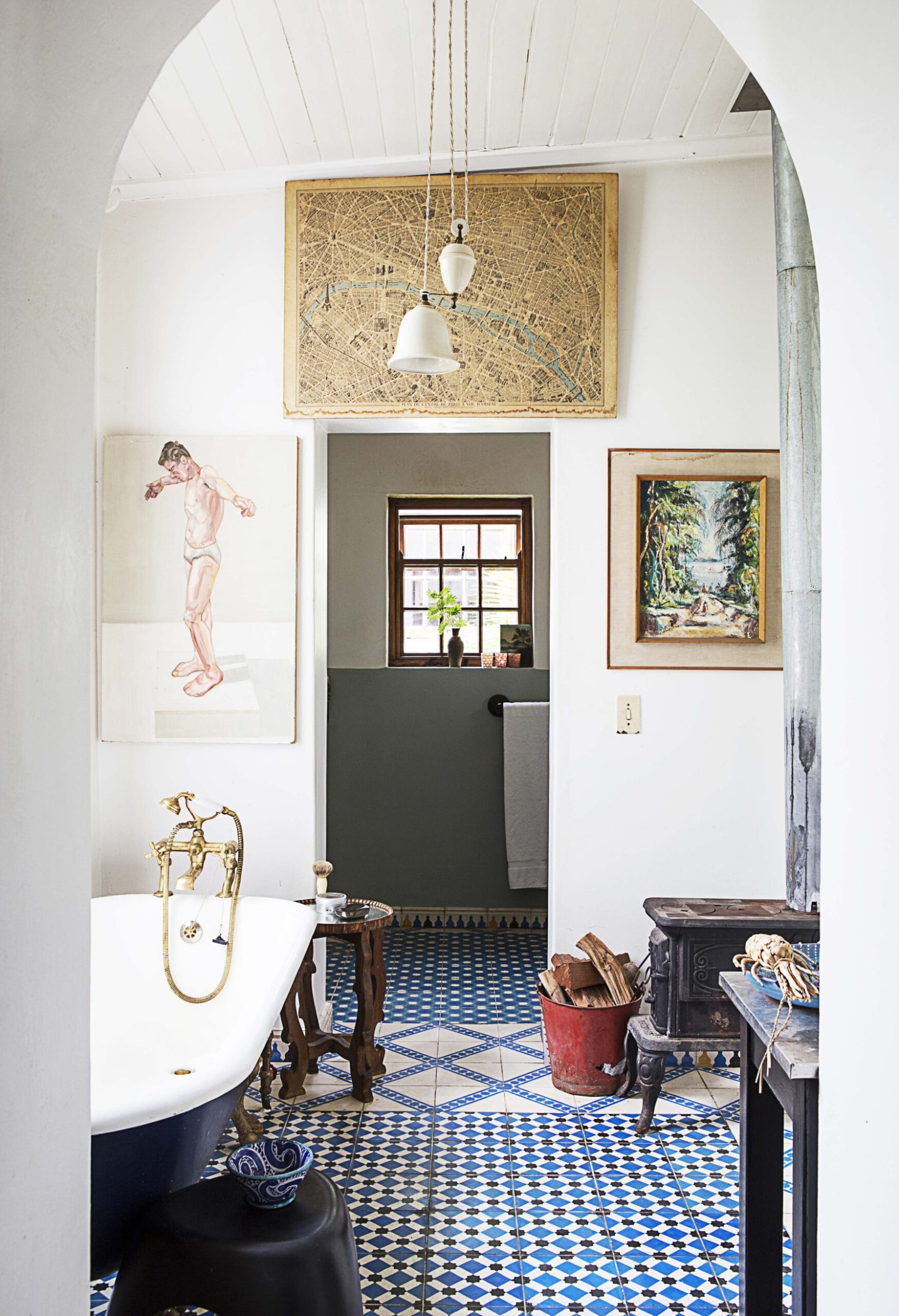 Bathroom with tall arched doors,  a blue clawfoot tub, blue and white geometric floor tiles
