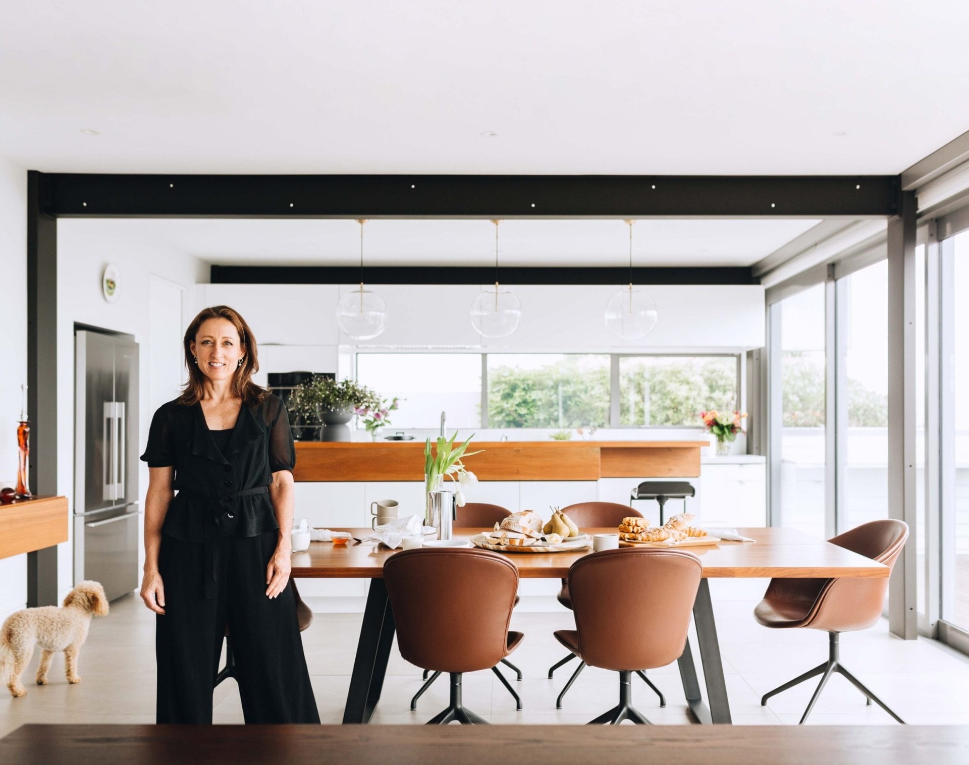 Frances Fraser standing in a kitchen with hanging pendant lights 