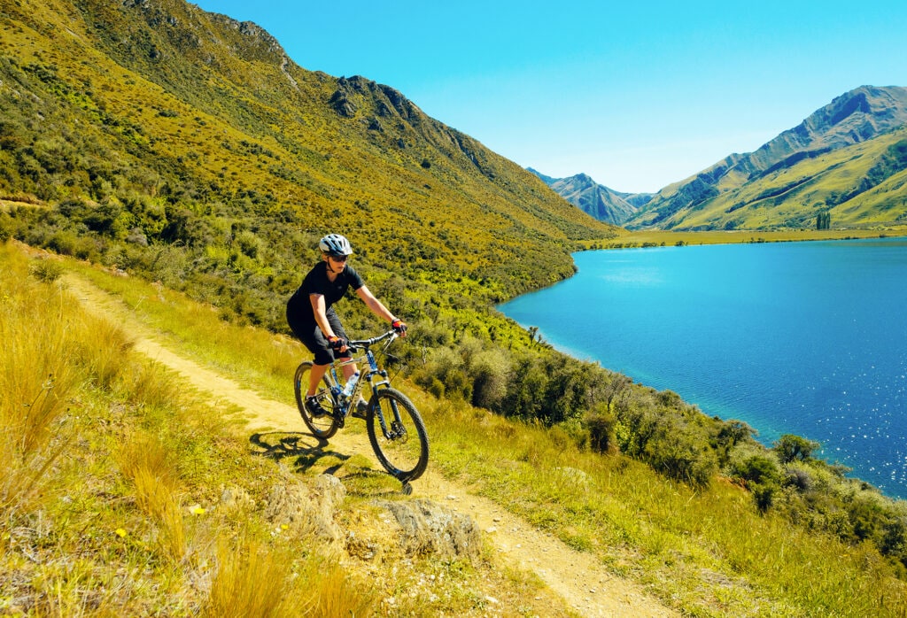 Person mountain biking on the Moke Lake Trail near Queenstown in New Zealand