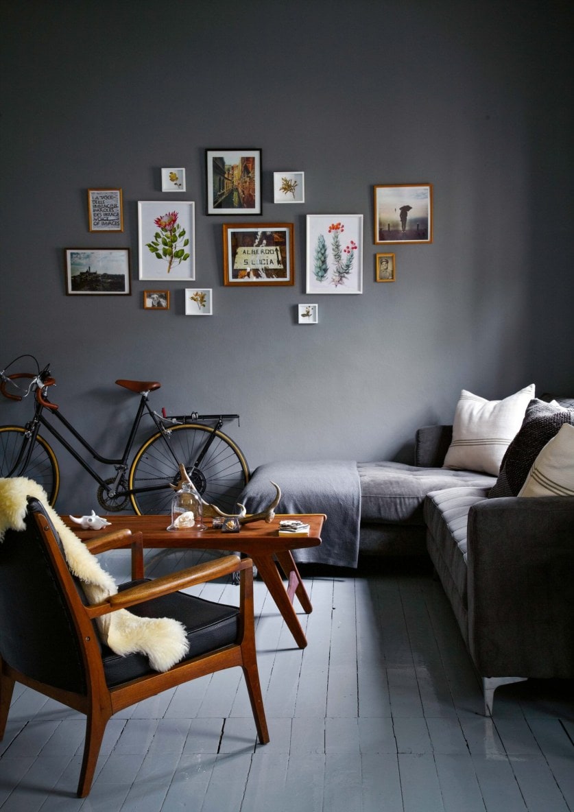 Living room with black walls, grey seats and chairs with timber backing