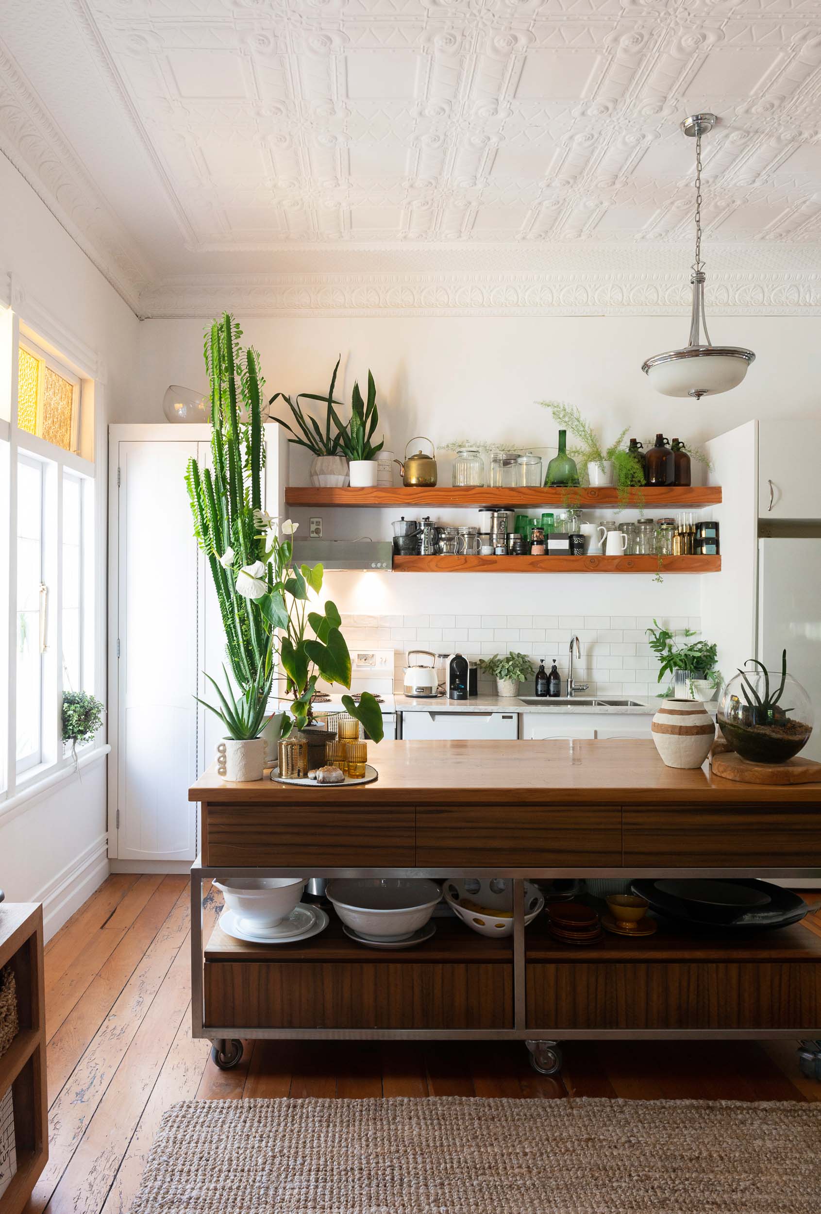 Kitchen with open shelves on the back wall and a trolley style island