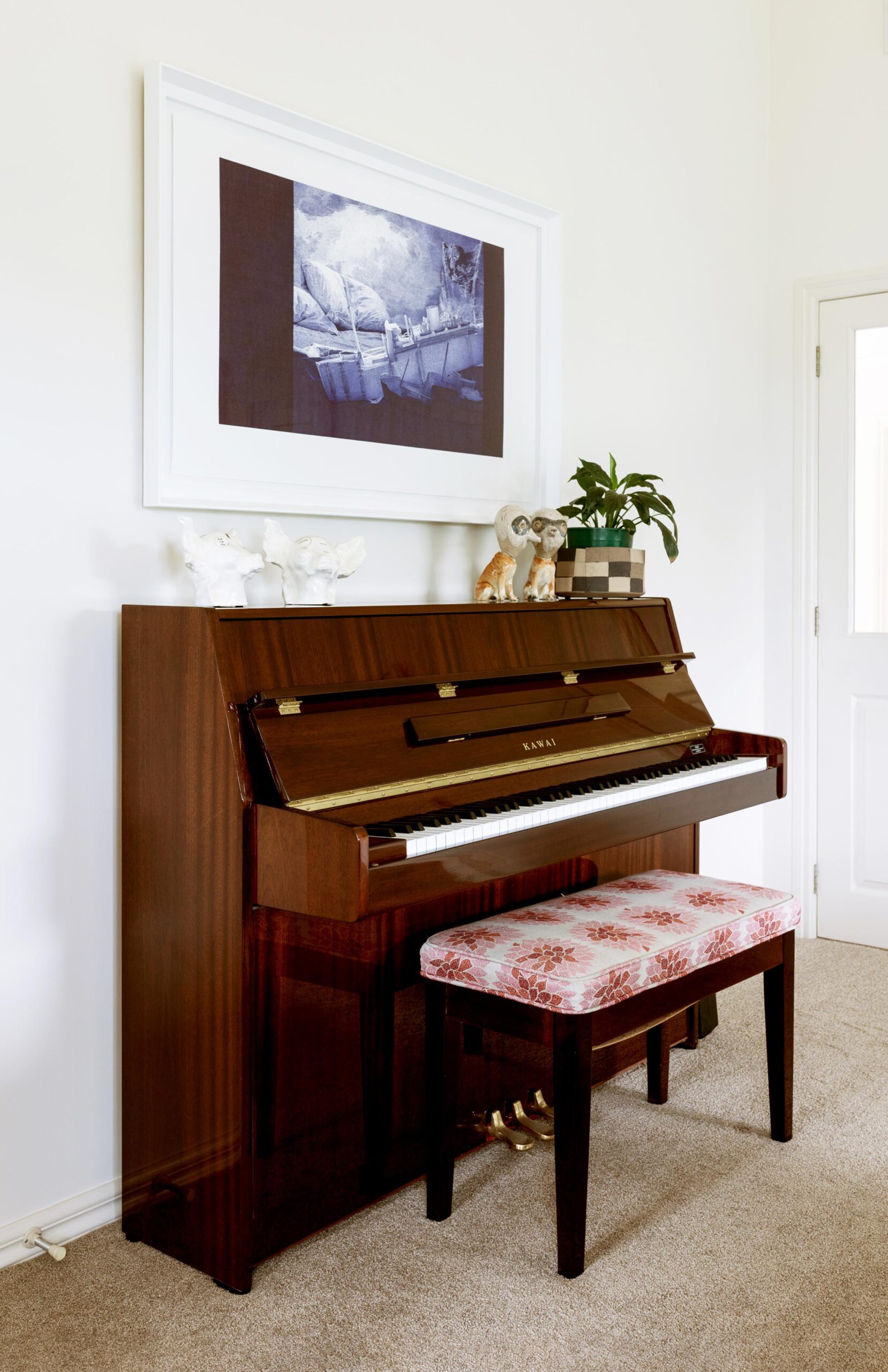 A piano with a large format art piece above it