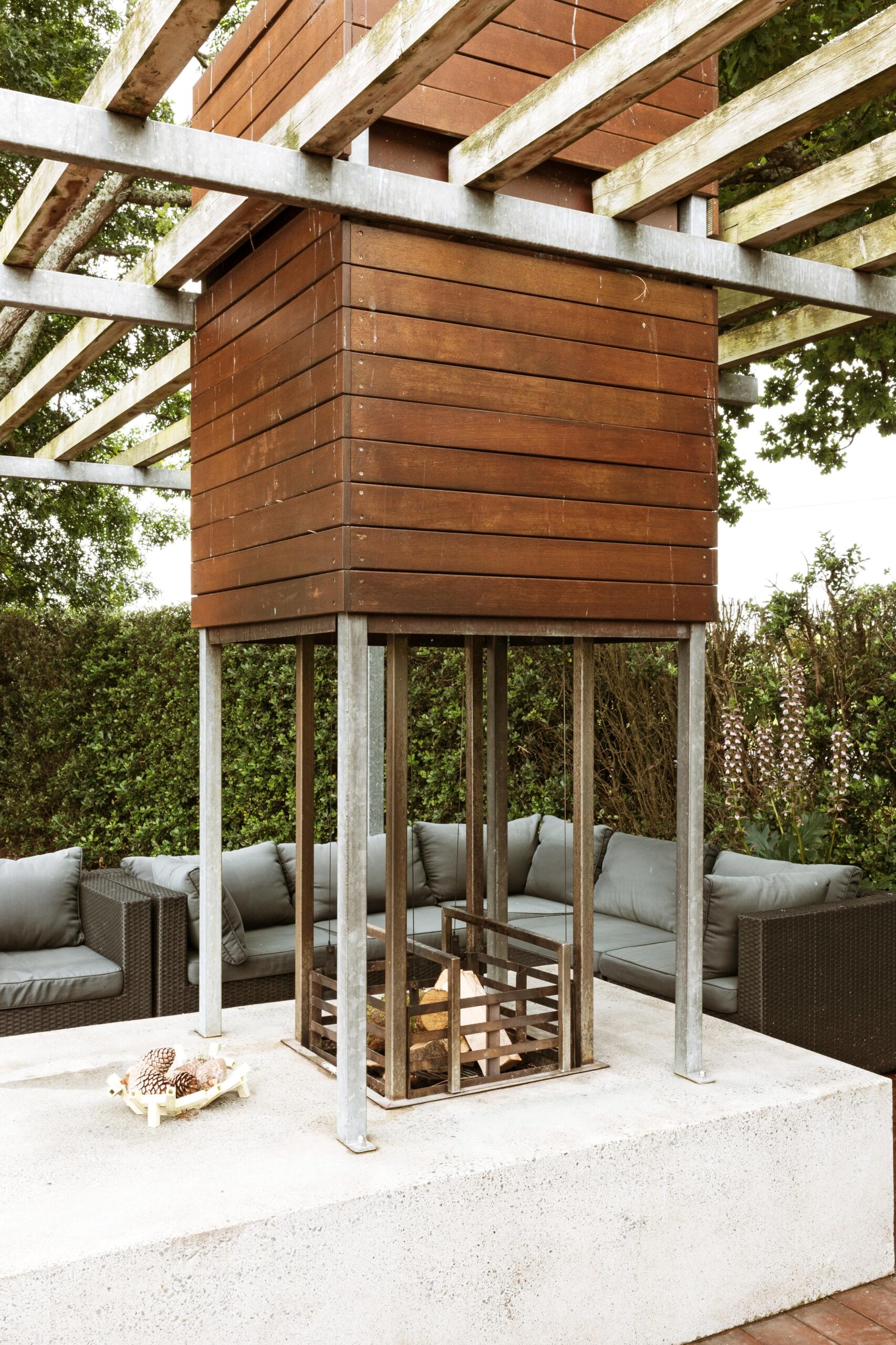 An outdoor fire-pit that has a timber chimney
