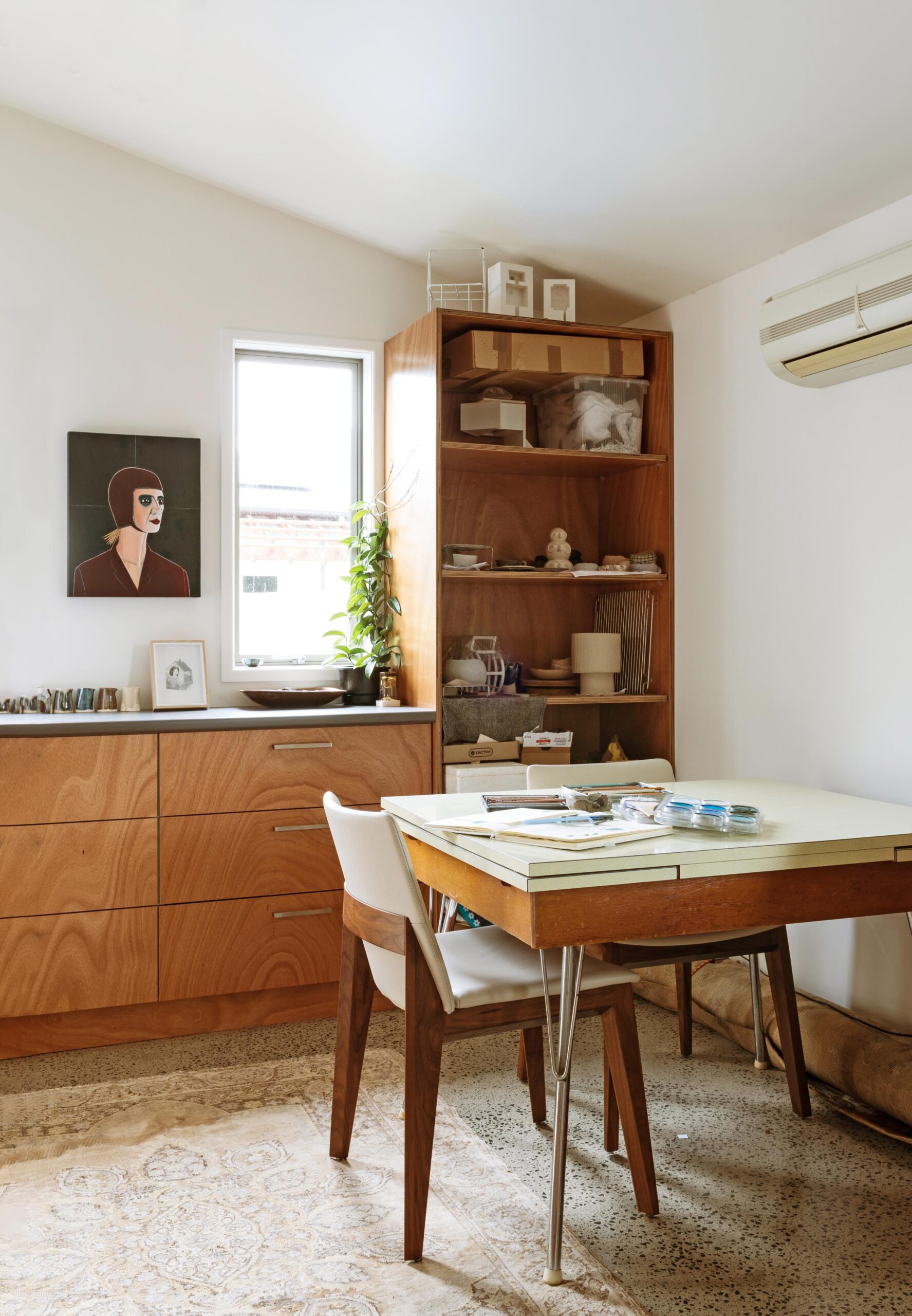 A workspace with cabinets and a workspace along the back wall and a formica table sitting in front