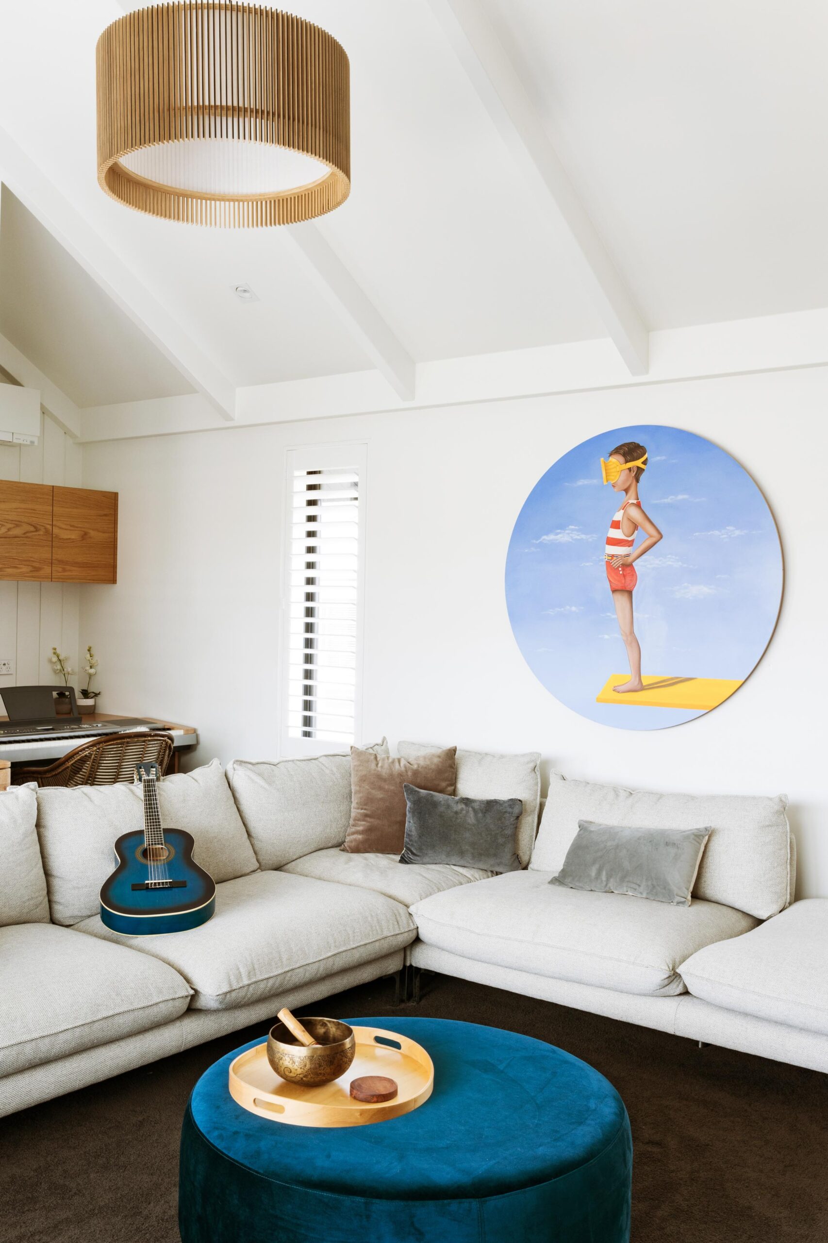 A large grey couch in a room with nautical artwork.