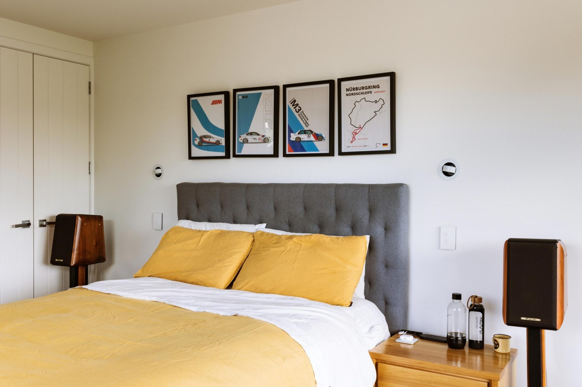 A large bed with yellow bedding and grey headboard.