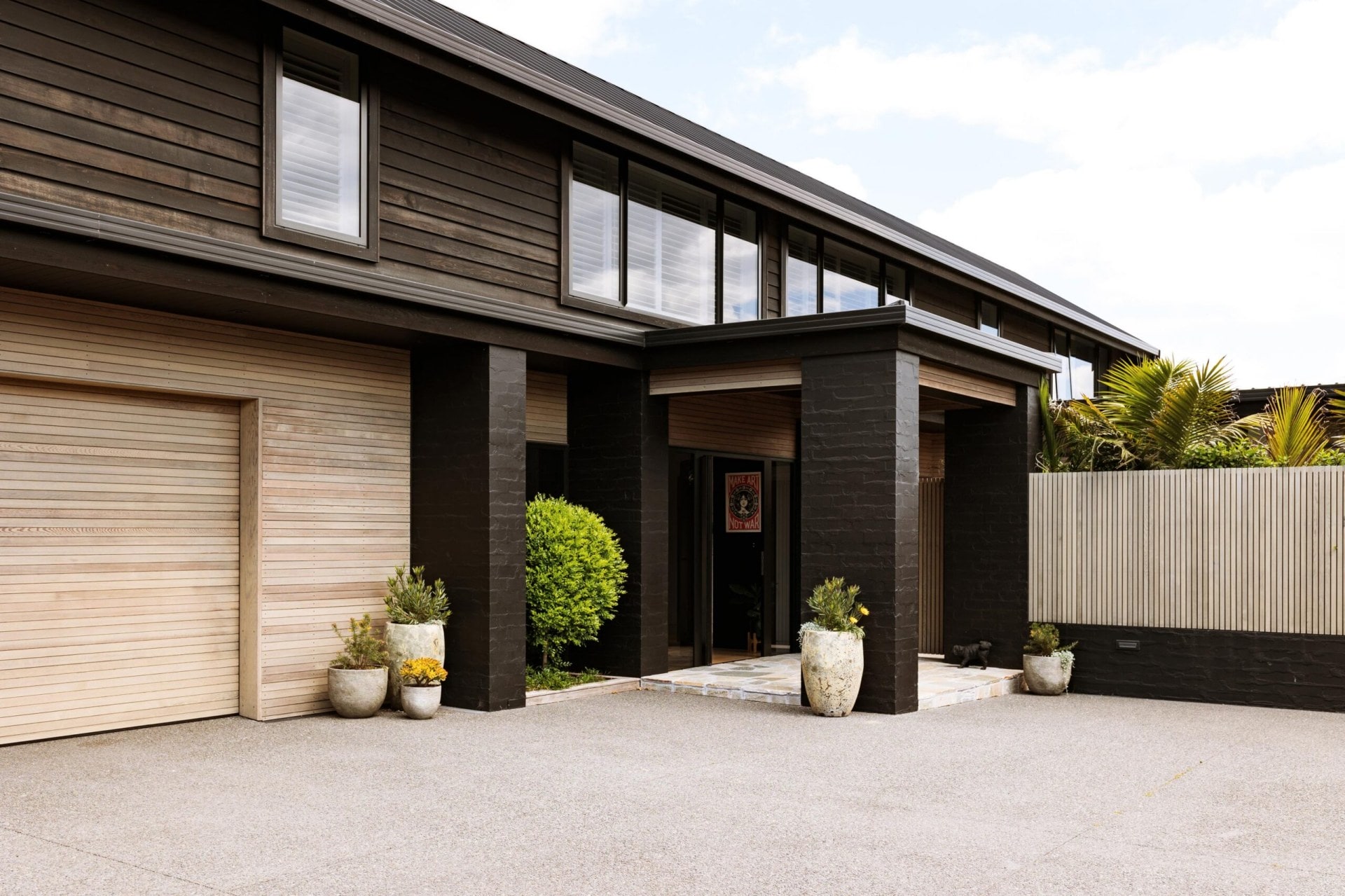 Exterior of dark brick and wooden house.