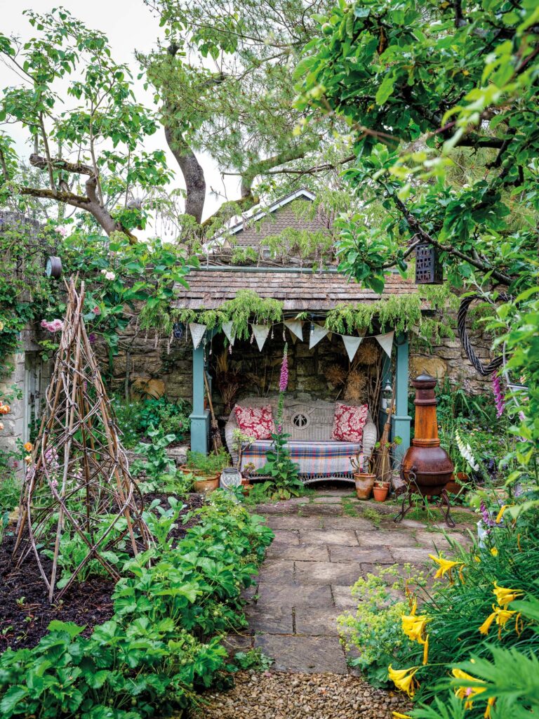 a bench with bunting and cushions in a garden