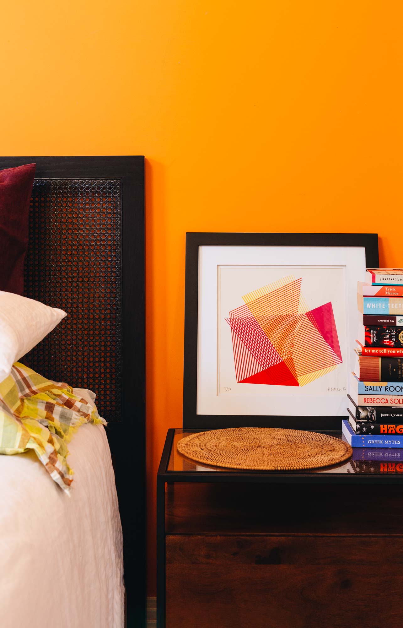 A bold orange painted wall in a bedroom