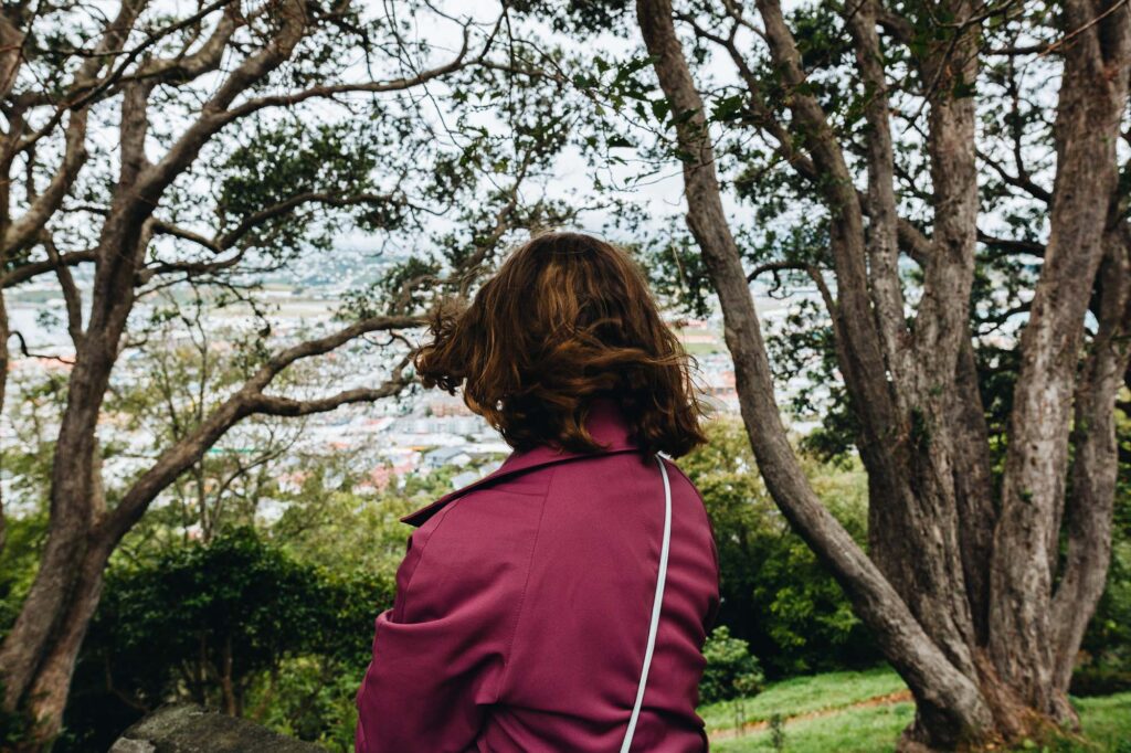 Jess harkins standing amongst trees looking over a vista