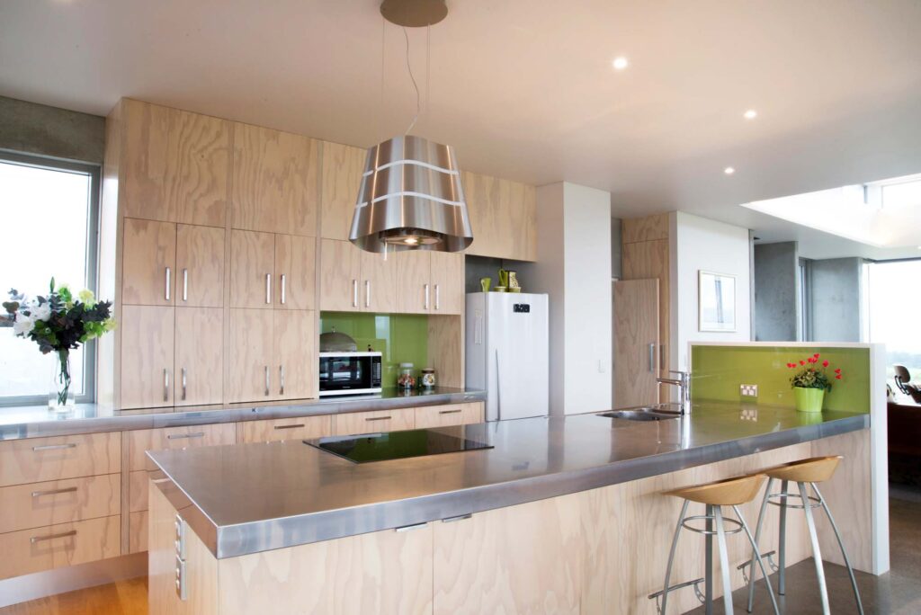 timber look kitchen with stainless steel benchtop and lime green splashback