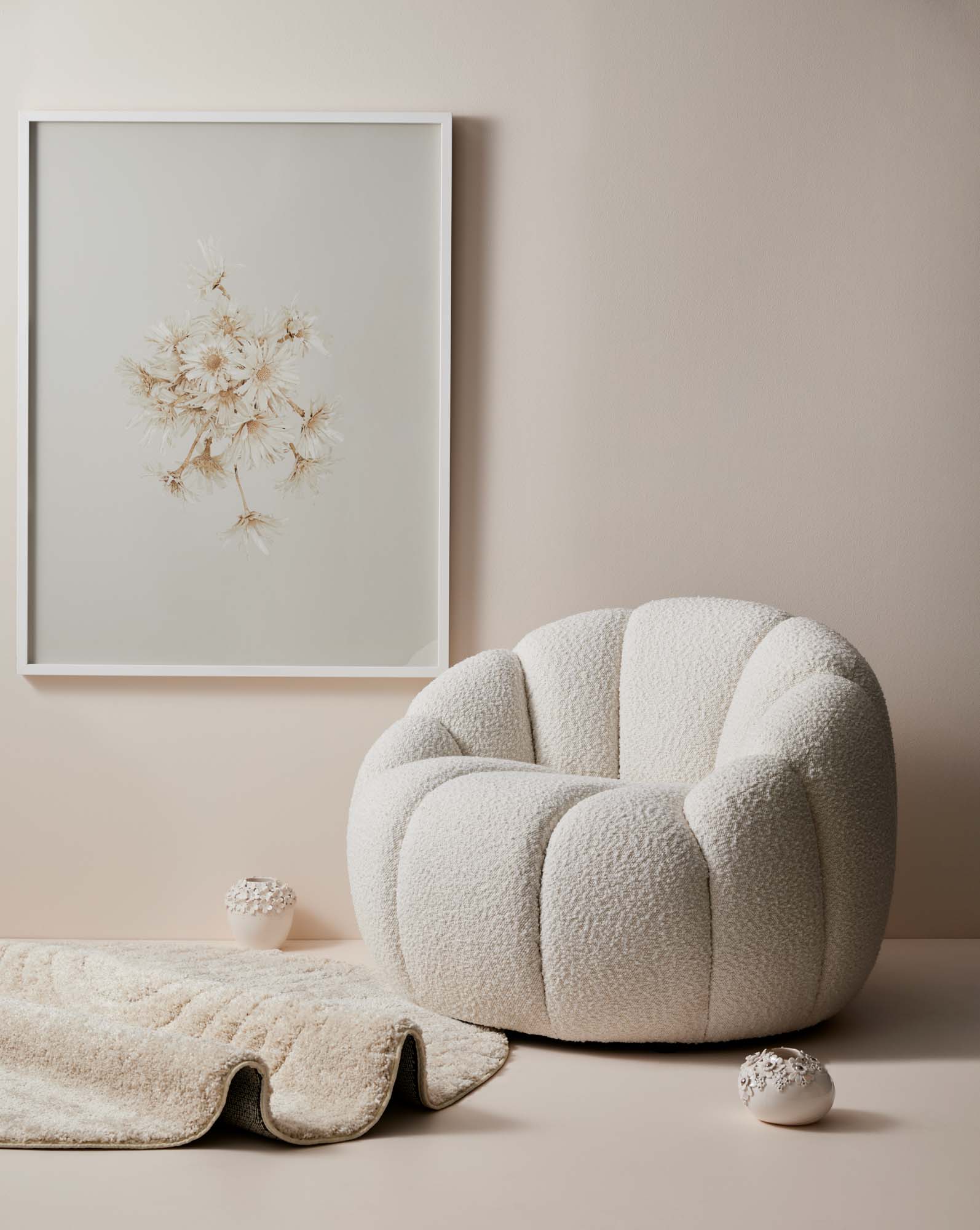 soft white walls with boucle rounded chair and large floral art on the wall and two vases on the floor