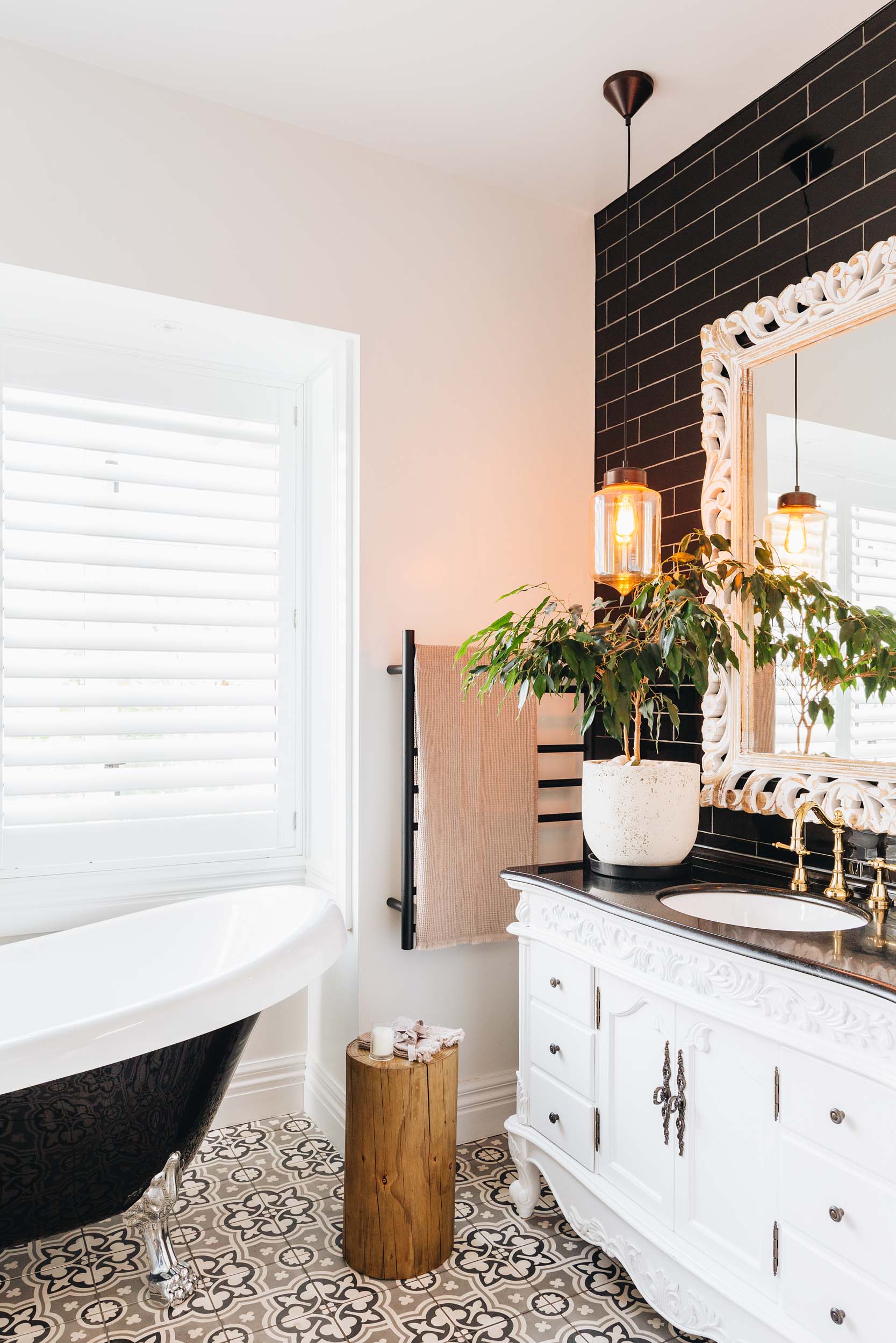 French-inspired bathroom with handpainted tiles, claw-foot roll top bath and french basin. 