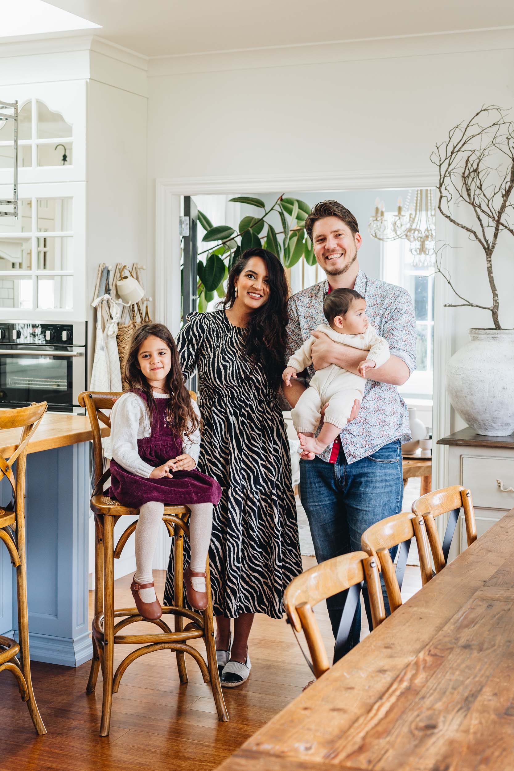 A family of four stand in their kitchen