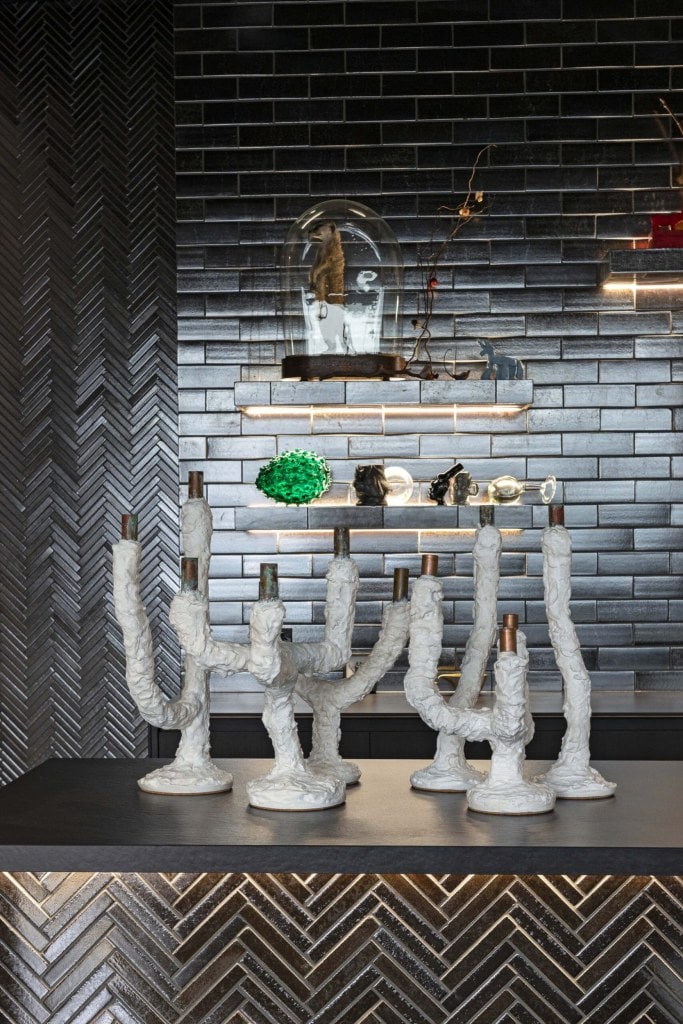 White candelabras by Ghastly Studios in all black kitchen