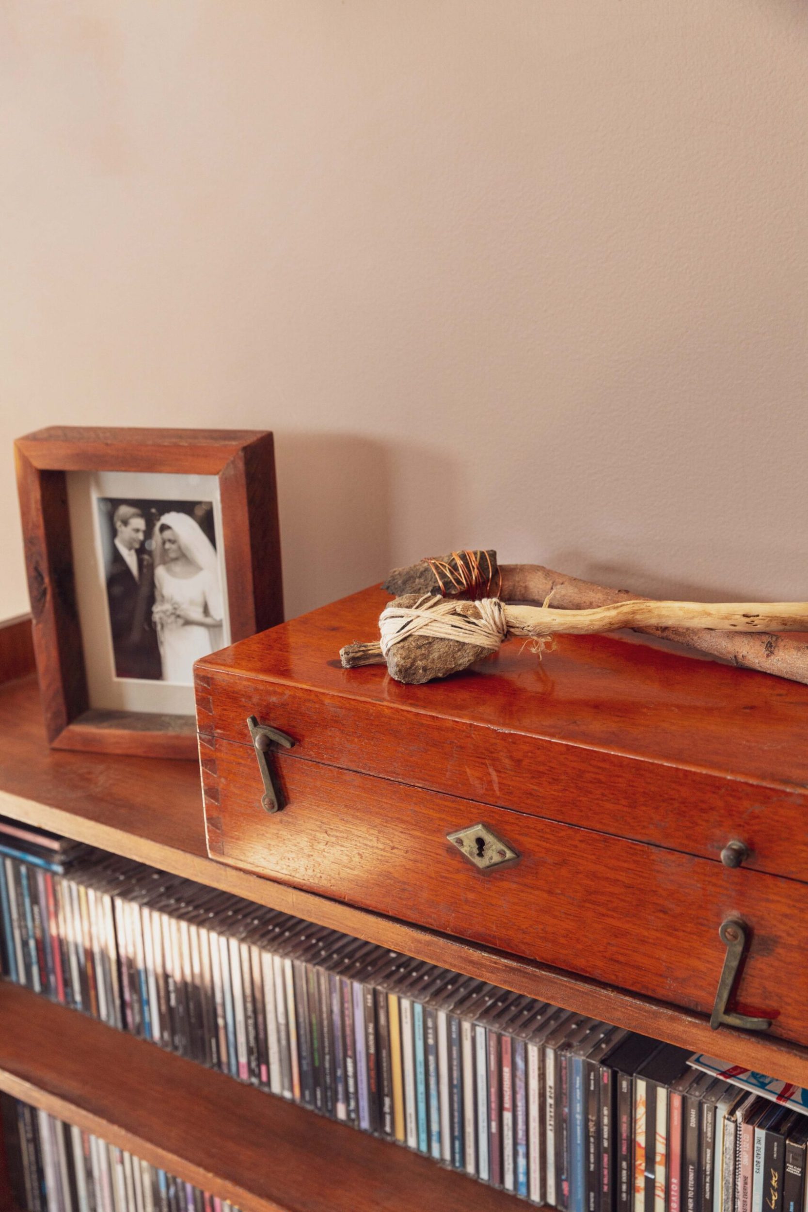 A wooden box sitting on a bookcase filled with CDS