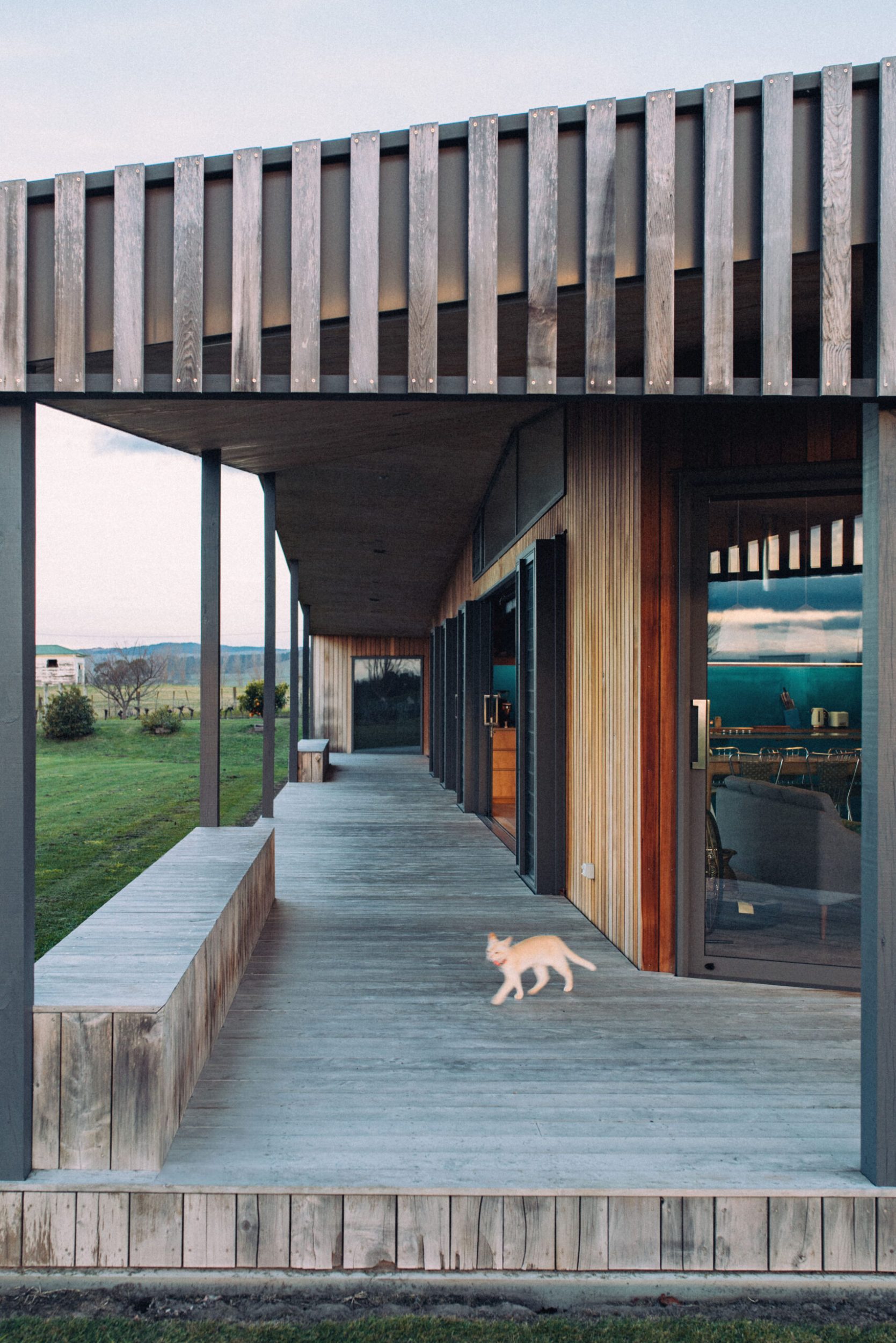 A wood deck next to a brown wooden house 