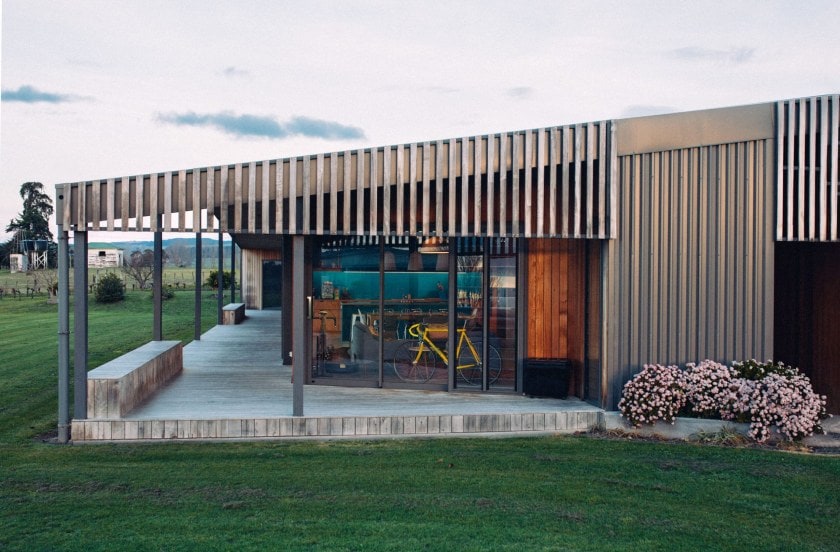 Exterior of a wood house with an angled roof, cedar cladding and window walls