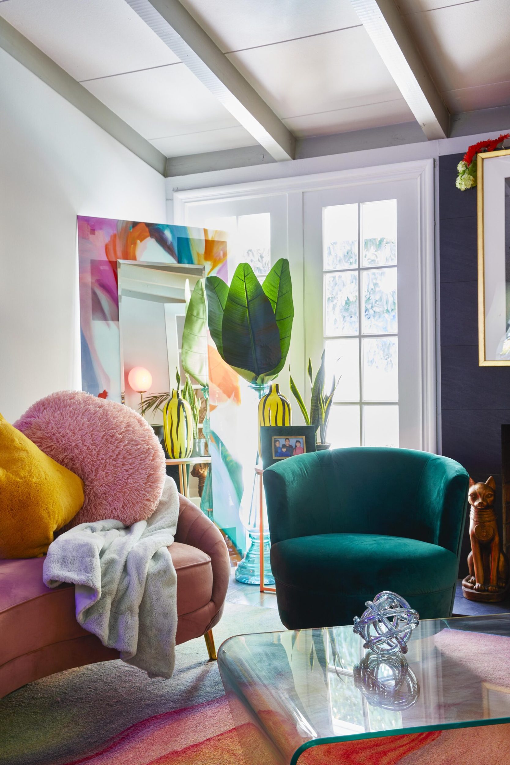 Parris Goebel's living room with a pink velvet couch, green velvet couch and colourful mirror