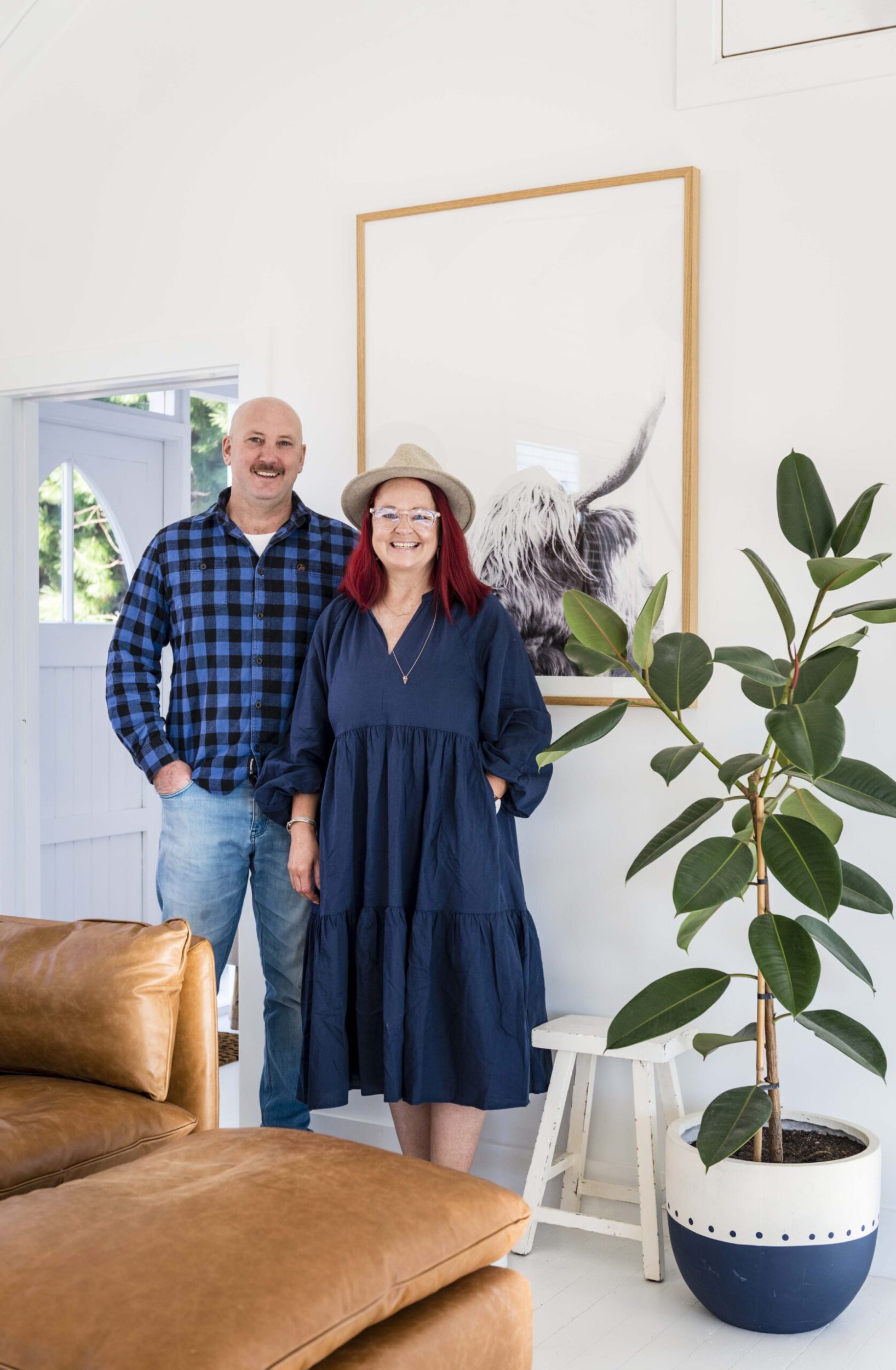 Caleb and Natalie Paterson standing in front of a highland cow print